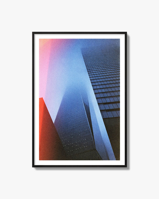 Fine art street photograph of the World Trade Center highlighting geometric shapes, with a dreamlike, cinematic feel in predominantly blue and red hues, archival pigment print in a black frame.