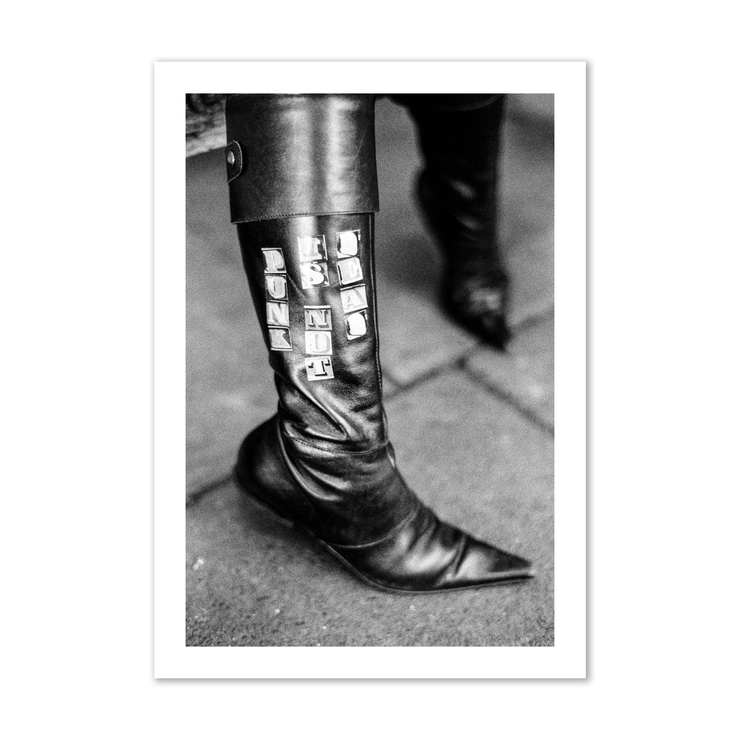 Fine art black and white photo of a woman's black leather boot with the words Punk is Not Dead, archival pigment print, collector size, unframed.