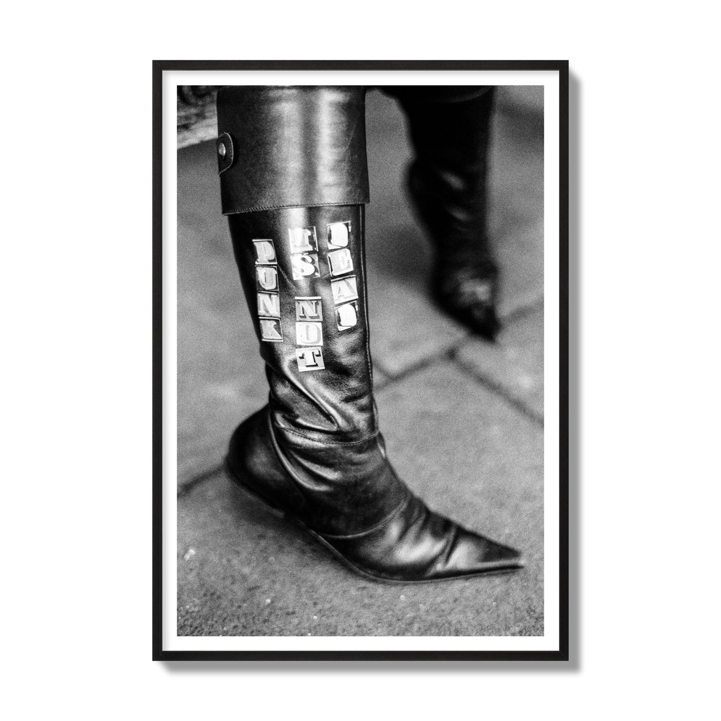 Fine art black and white photo of a woman's black leather boot with the words Punk is Not Dead, archival pigment print, gallery size, black frame.