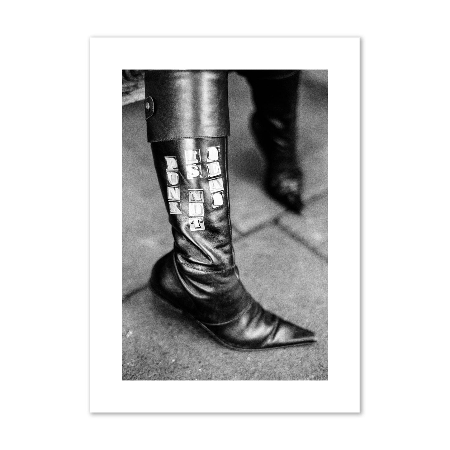 Fine art black and white photo of a woman's black leather boot with the words Punk is Not Dead, archival pigment print, giant size, unframed.