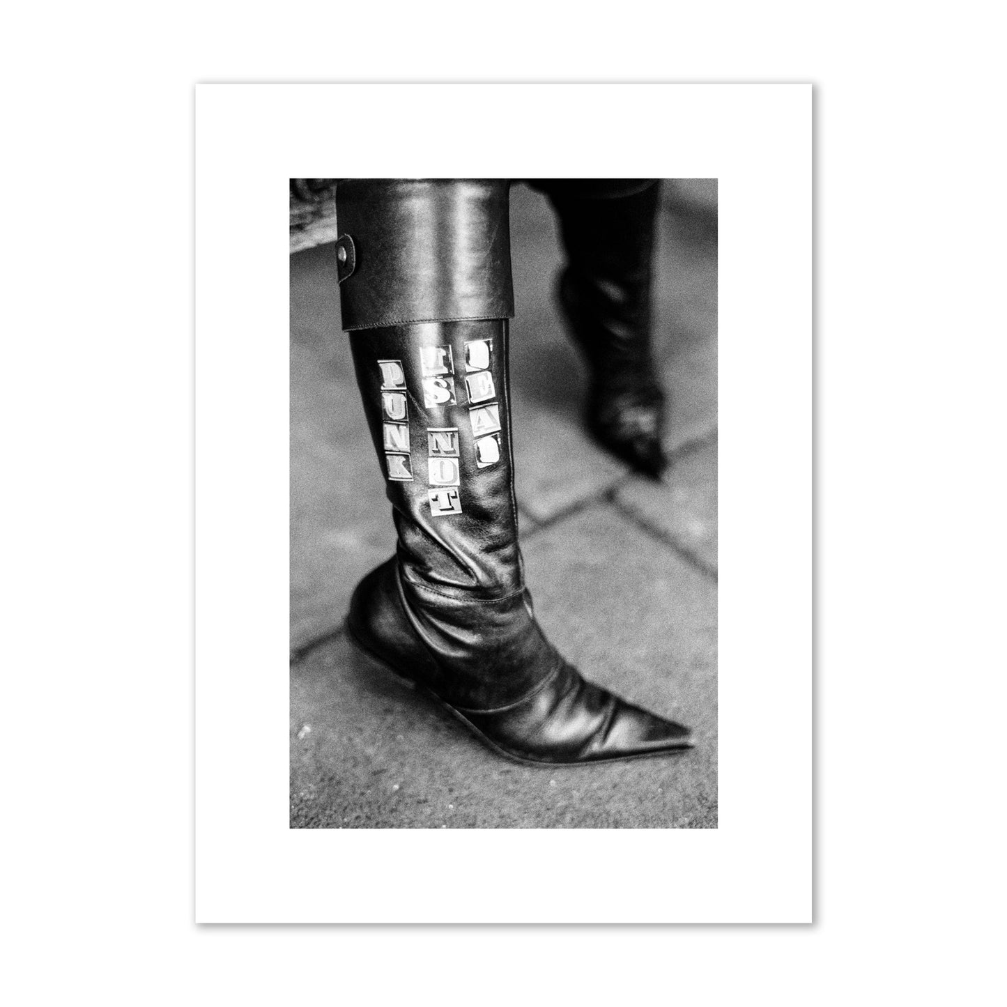 Fine art black and white photo of a woman's black leather boot with the words Punk is Not Dead, archival pigment print, medium size, unframed.