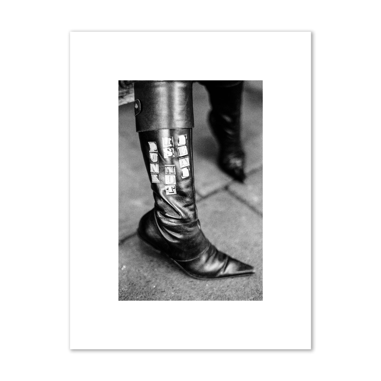 Fine art black and white photo of a woman's black leather boot with the words Punk is Not Dead, archival pigment print, small size, unframed.