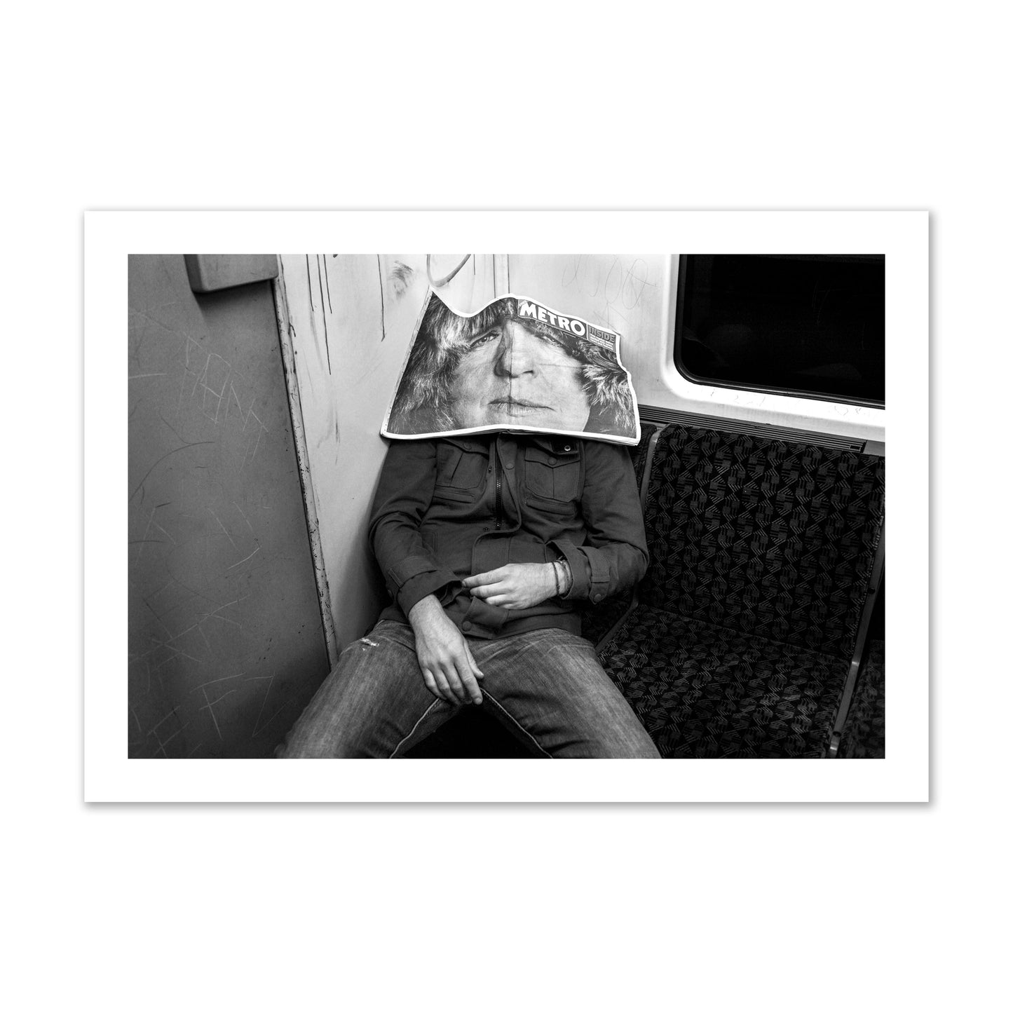 Fine art photograph of a man asleep on the subway with a newspaper covering their face, archival pigment print, collector size, unframed.