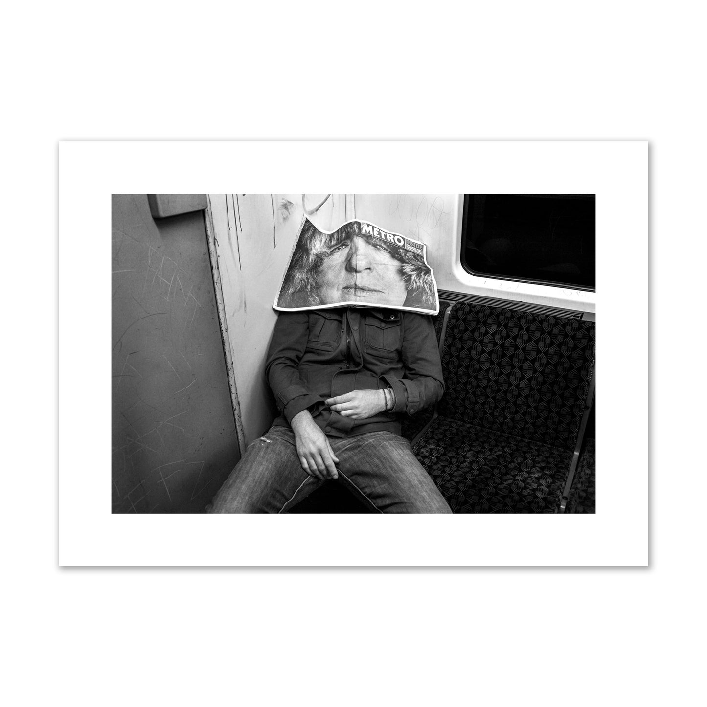 Fine art photograph of a man asleep on the subway with a newspaper covering their face, archival pigment print, large size, unframed.