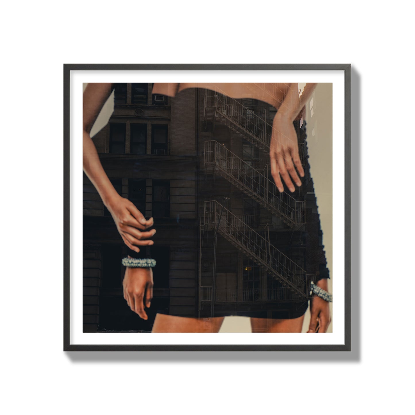 Fine art photograph of two women in black dresses, with the pattern of a fire escape reflected across the fabric, archival pigment print, gallery size, black frame.