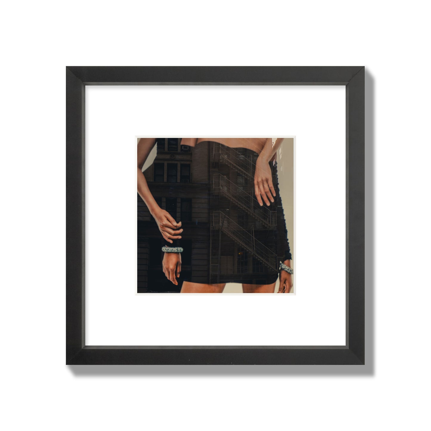 Fine art photograph of two women in black dresses, with the pattern of a fire escape reflected across the fabric, archival pigment print, small size, black frame.