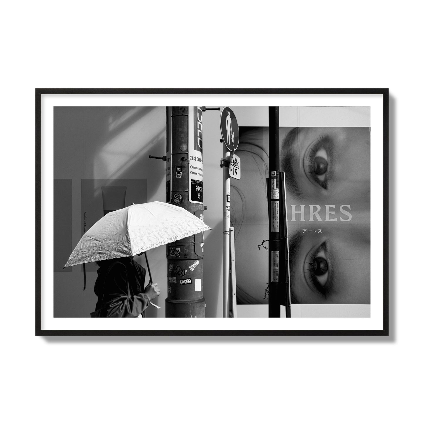 Fine art street photograph of a woman walking with an umbrella on a Tokyo street, passing beneath a billboard with two large eyes. Archival pigment print, collector size, black frame.