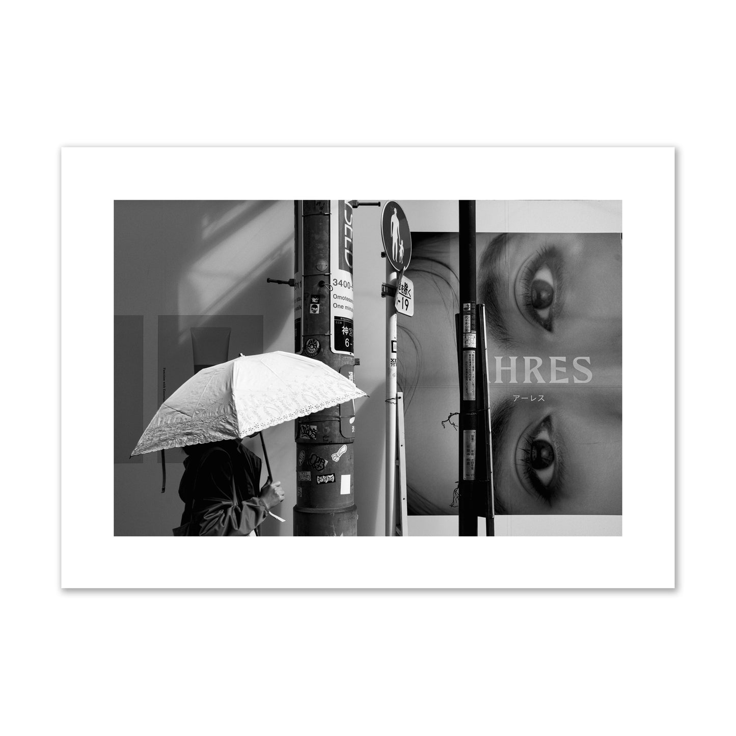 Fine art street photograph of a woman walking with an umbrella on a Tokyo street, passing beneath a billboard with two large eyes. Archival pigment print, giant size, unframed.