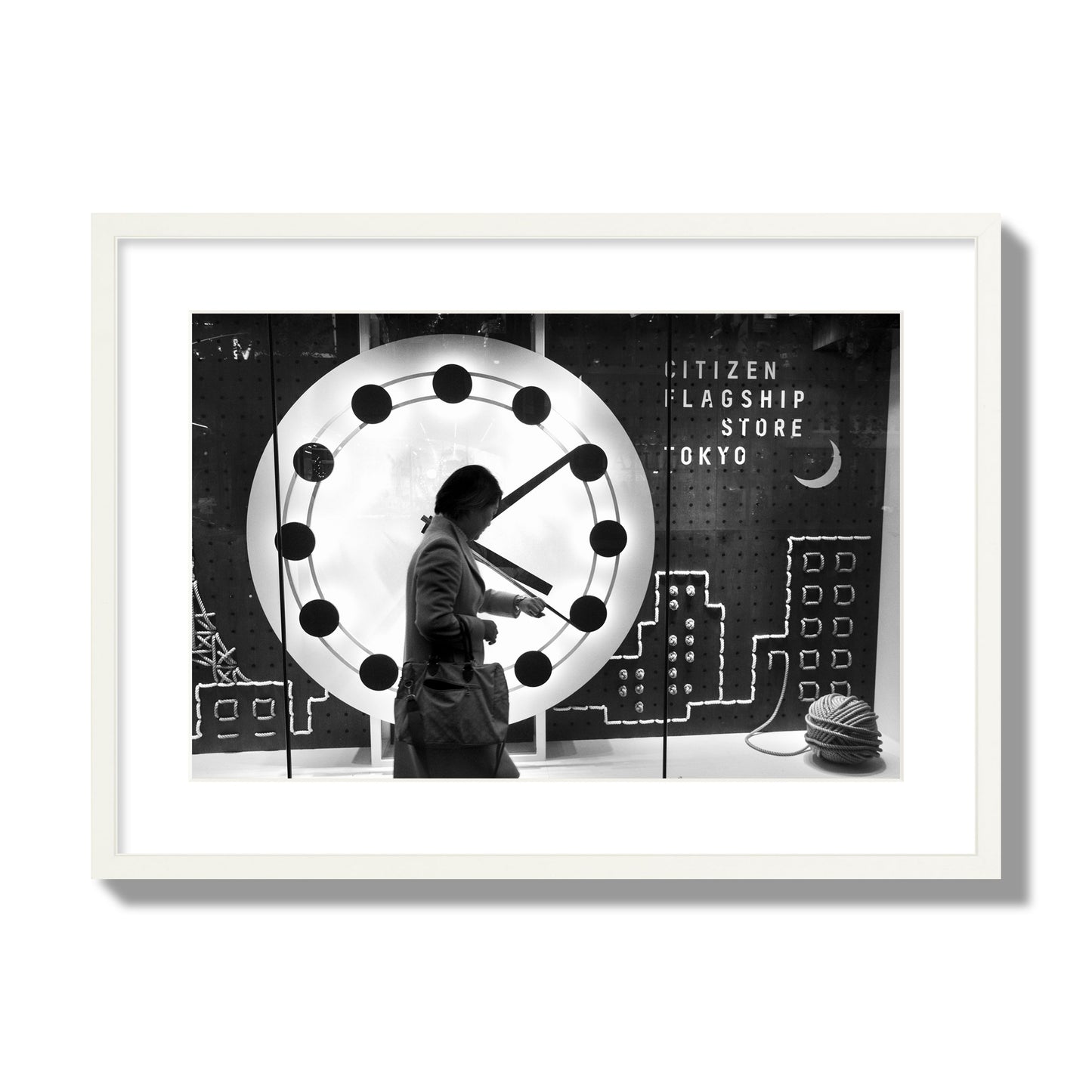 Fine art street photograph of a woman checking her watch as she walks past a giant clock on a busy Tokyo city street. Archival pigment print, large size, white frame.