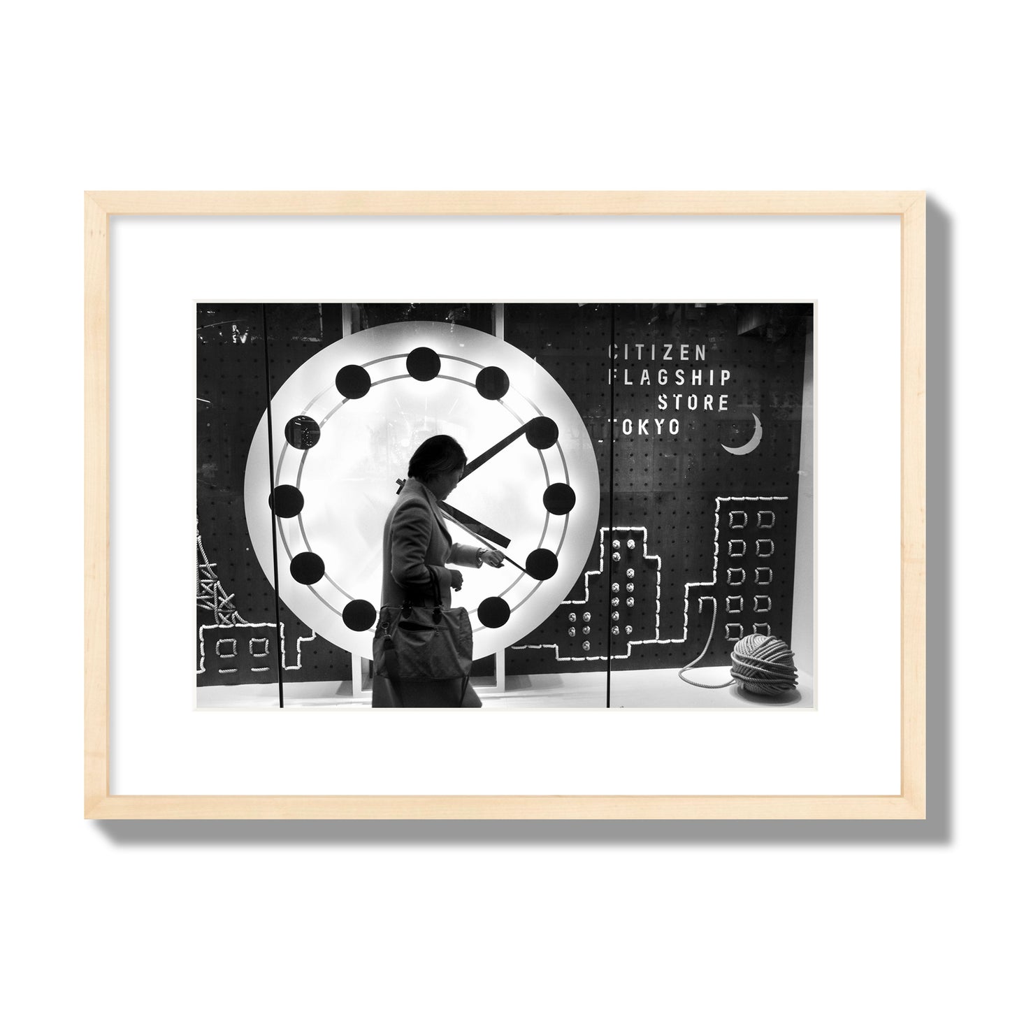 Fine art street photograph of a woman checking her watch as she walks past a giant clock on a busy Tokyo city street. Archival pigment print, medium size, natural wood frame.