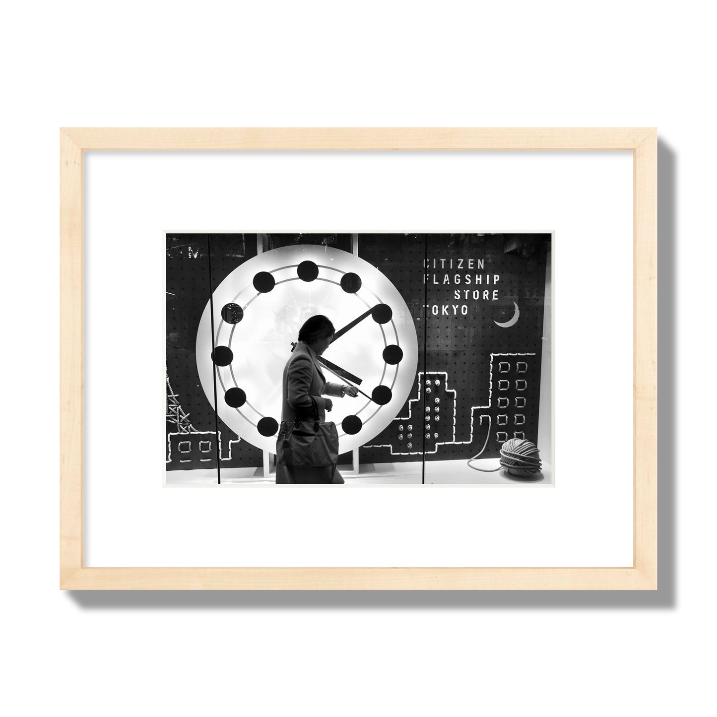 Fine art street photograph of a woman checking her watch as she walks past a giant clock on a busy Tokyo city street. Archival pigment print, small size, natural wood frame.