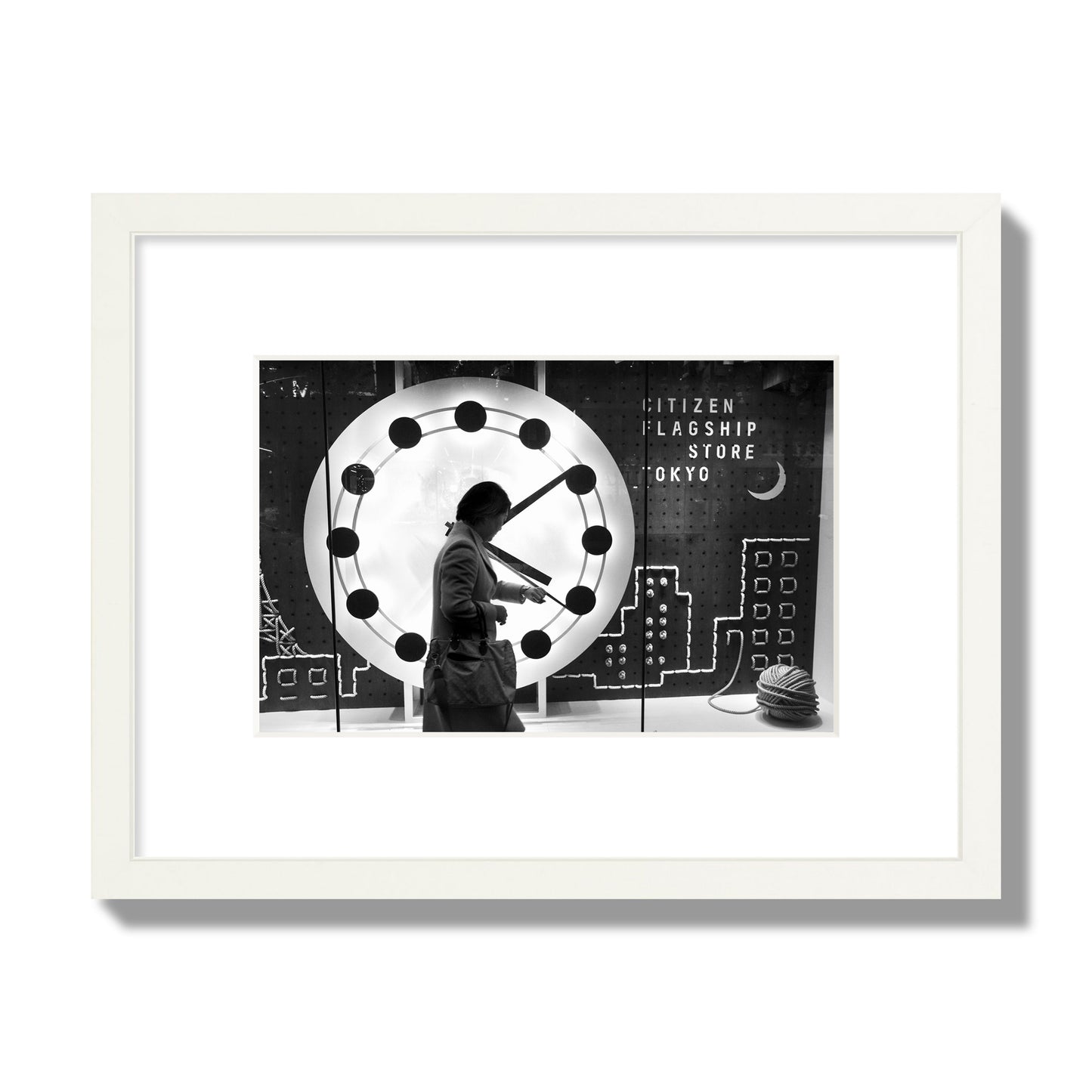 Fine art street photograph of a woman checking her watch as she walks past a giant clock on a busy Tokyo city street. Archival pigment print, small size, white frame.