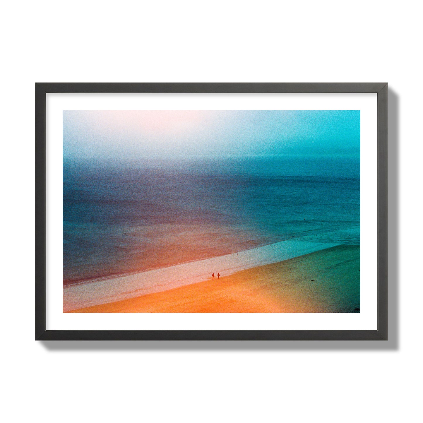 Fine art street photograph of a serene beach with two figures walking in the distance, captured in a dreamlike composition with soft orange and blue hues. Archival pigment print, giant size, black frame.