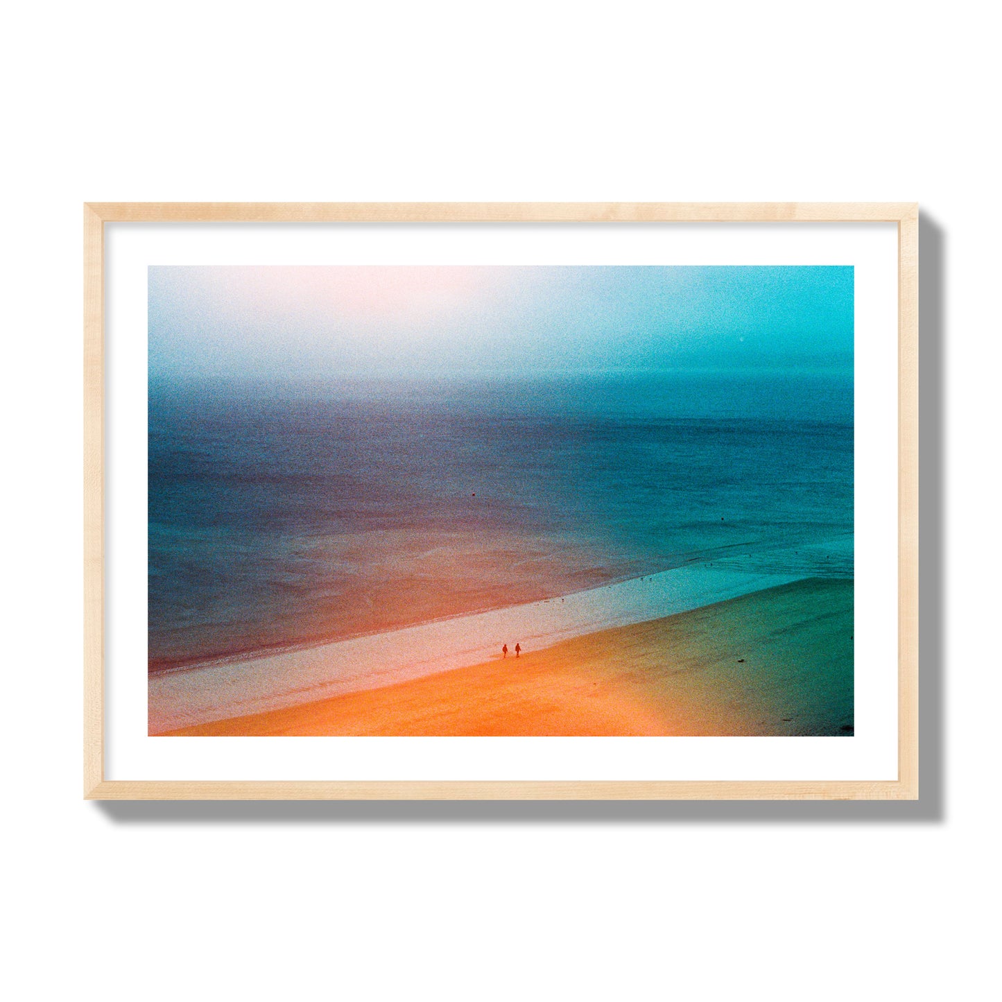 Fine art street photograph of a serene beach with two figures walking in the distance, captured in a dreamlike composition with soft orange and blue hues. Archival pigment print, giant size, natural wood frame.