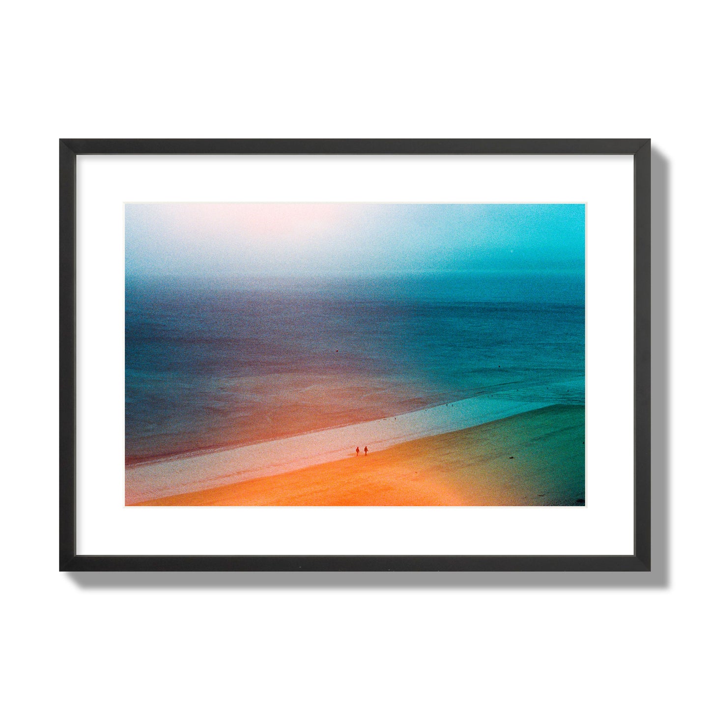 Fine art street photograph of a serene beach with two figures walking in the distance, captured in a dreamlike composition with soft orange and blue hues. Archival pigment print, large size, black frame.