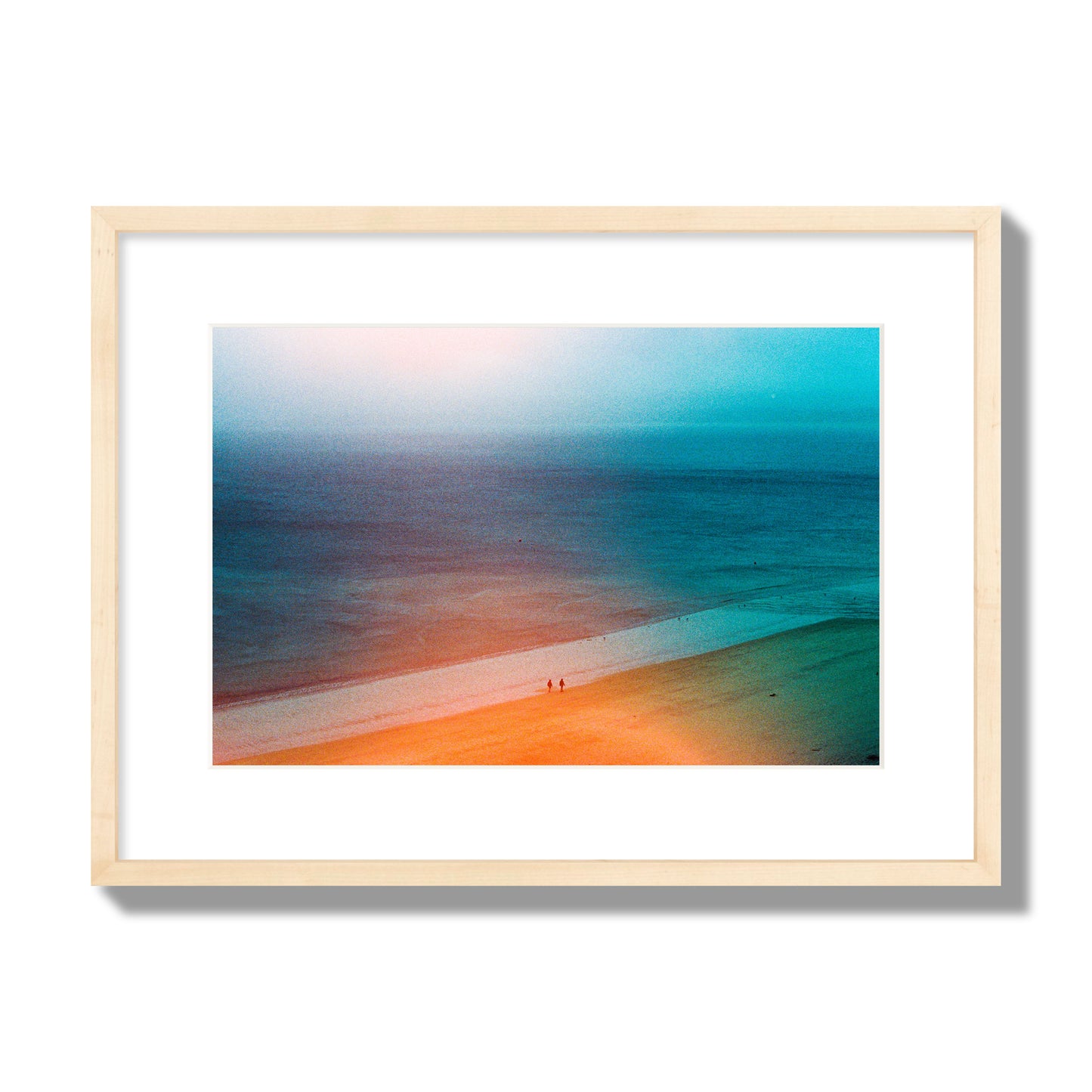 Fine art street photograph of a serene beach with two figures walking in the distance, captured in a dreamlike composition with soft orange and blue hues. Archival pigment print, medium size, natural wood frame.