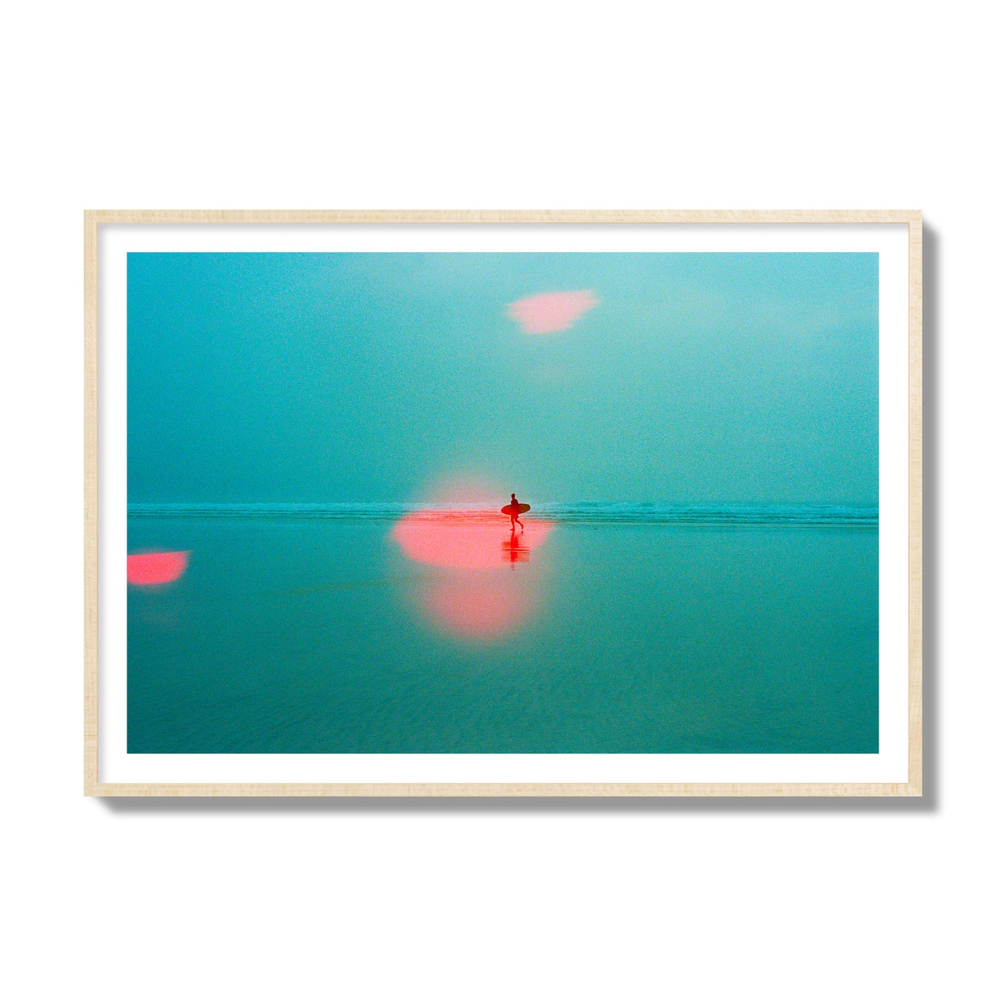 Fine art street photograph of a tranquil beach with a surfer running toward the waves, featuring a dreamlike composition with soft teal tones and a striking red lens flare. Archival pigment print, collector size, natural wood frame.
