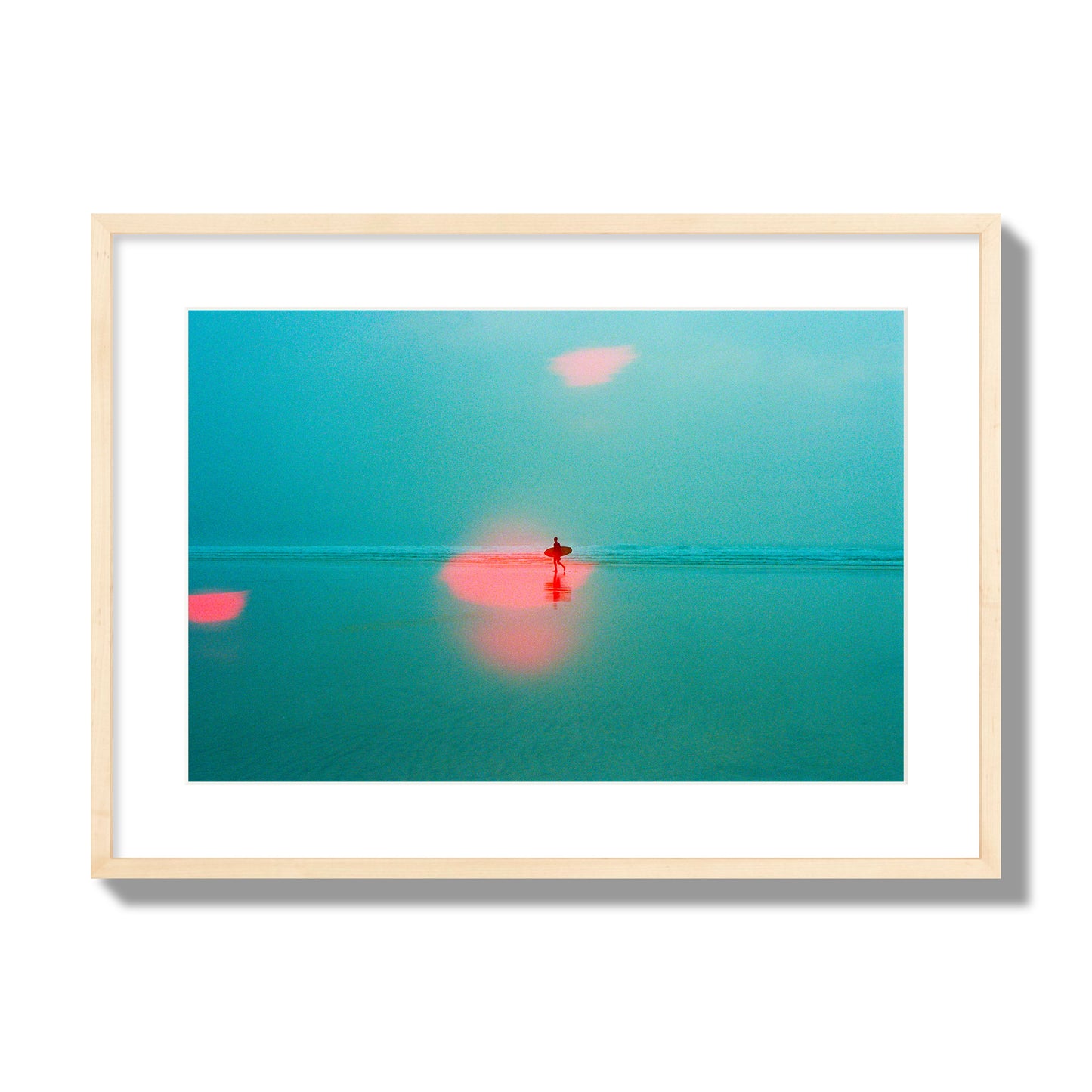 Fine art street photograph of a tranquil beach with a surfer running toward the waves, featuring a dreamlike composition with soft teal tones and a striking red lens flare. Archival pigment print, large size, natural wood frame.