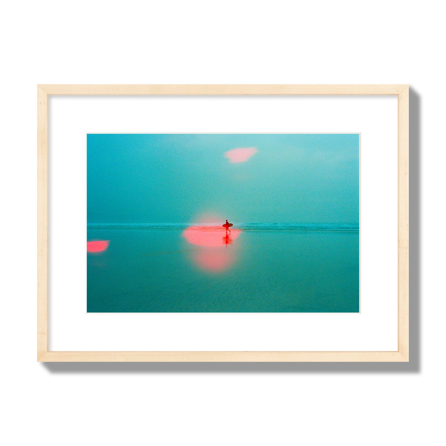 Fine art street photograph of a tranquil beach with a surfer running toward the waves, featuring a dreamlike composition with soft teal tones and a striking red lens flare. Archival pigment print, medium size, natural wood frame.