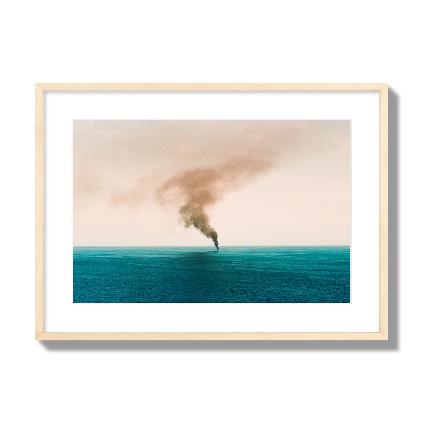 Fine art street photograph of a moody seascape with smoke rising from a distant boat, capturing a sense of mystery and atmosphere. Archival pigment print, large size, natural wood frame.