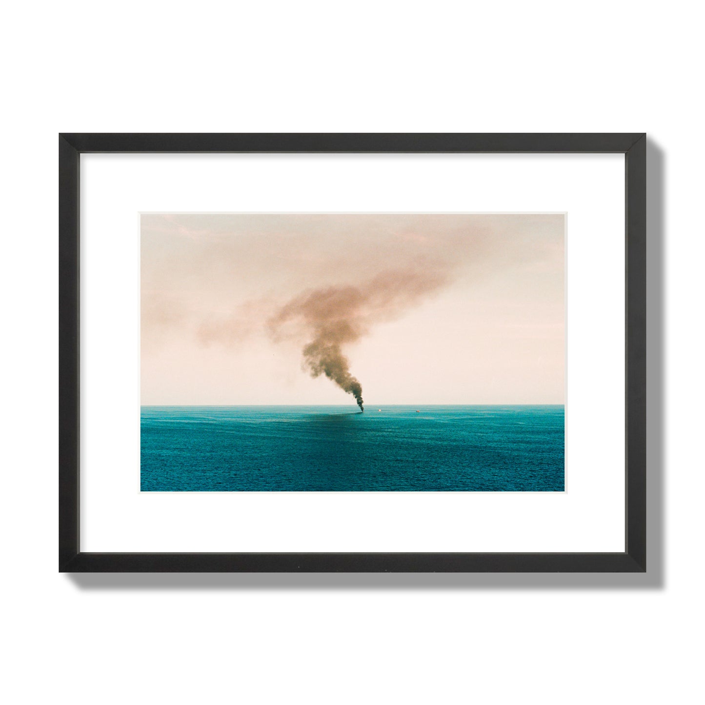 Fine art street photograph of a moody seascape with smoke rising from a distant boat, capturing a sense of mystery and atmosphere. Archival pigment print, medium size, black frame.
