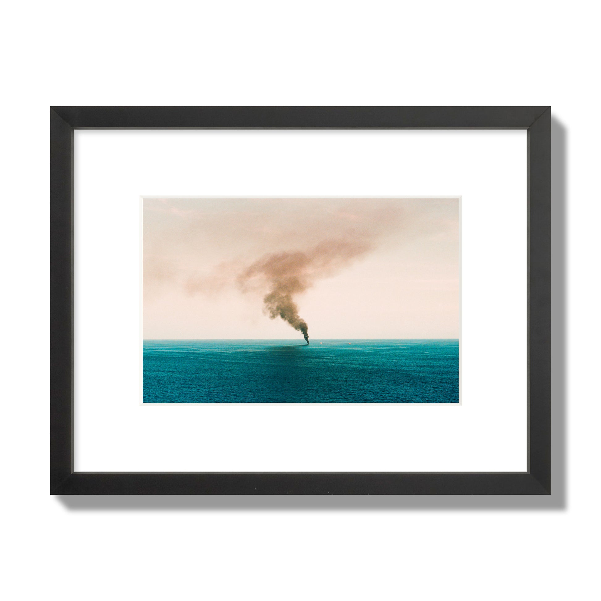 Fine art street photograph of a moody seascape with smoke rising from a distant boat, capturing a sense of mystery and atmosphere. Archival pigment print, small size, black frame.