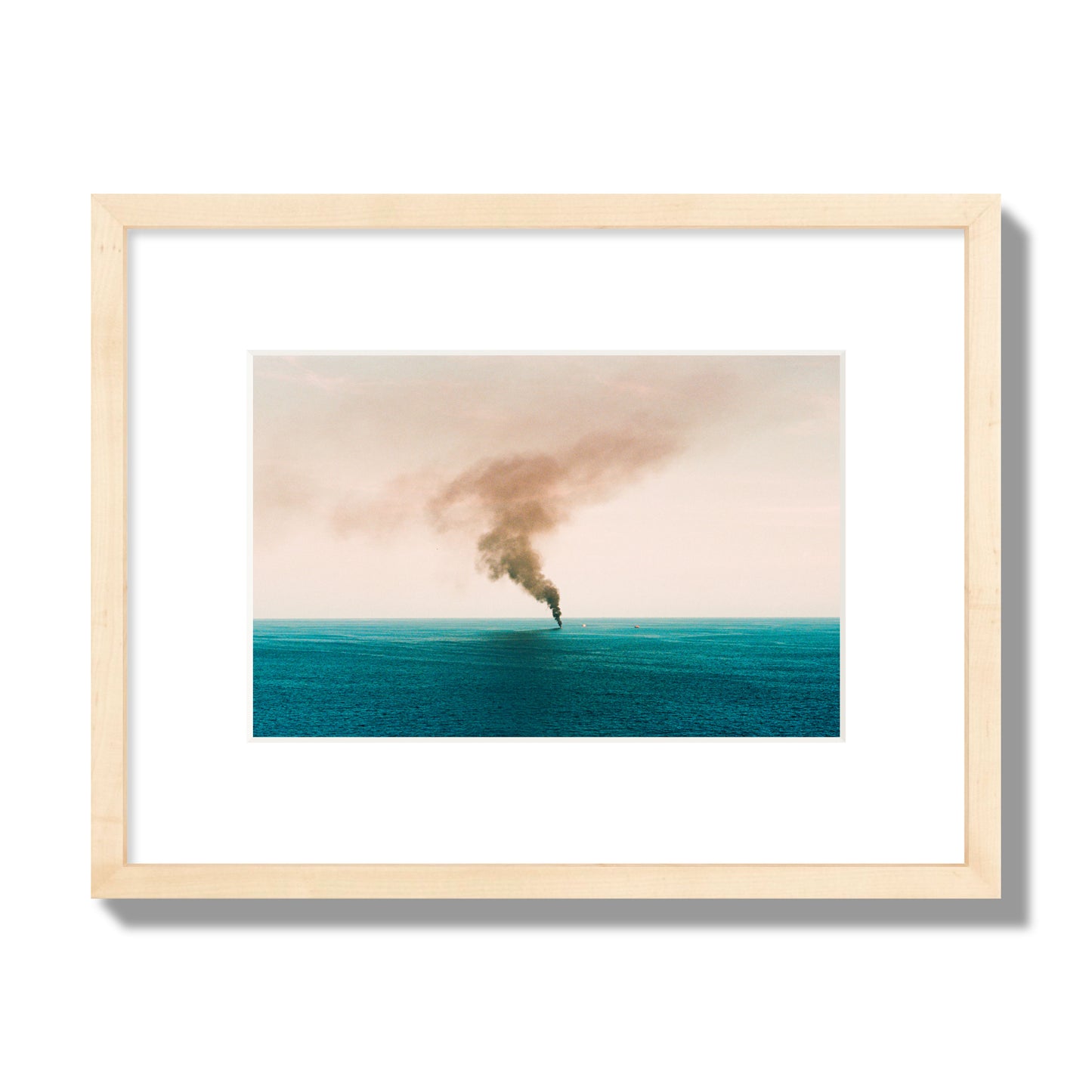 Fine art street photograph of a moody seascape with smoke rising from a distant boat, capturing a sense of mystery and atmosphere. Archival pigment print, small size, natural wood frame.