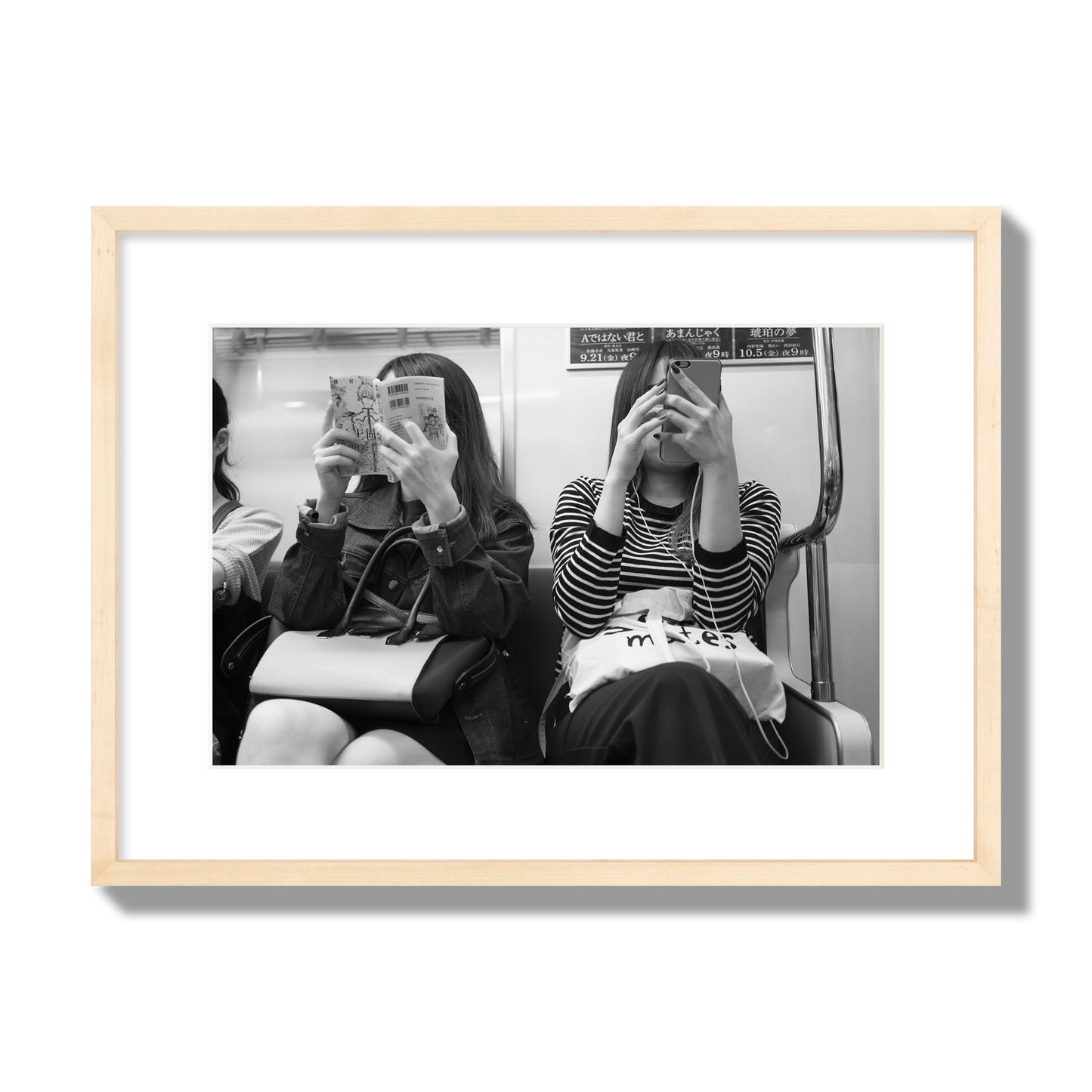 Black and white fine art photograph of two women on the Tokyo Metro, archival pigment print, medium size, natural wood frame