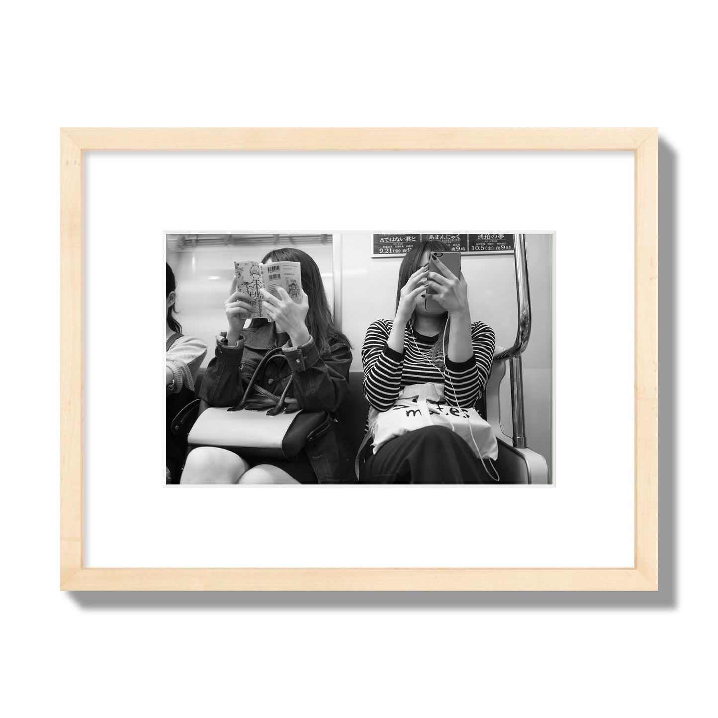 Black and white fine art photograph of two women on the Tokyo Metro, archival pigment print, small size, natural wood frame
