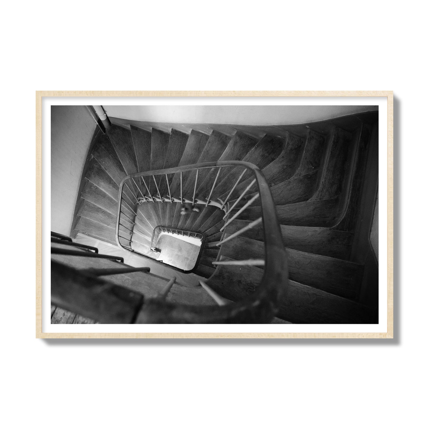 Fine art street photograph of a person walking down a staircase in Paris, France, archival pigment print, gallery size, natural wood frame