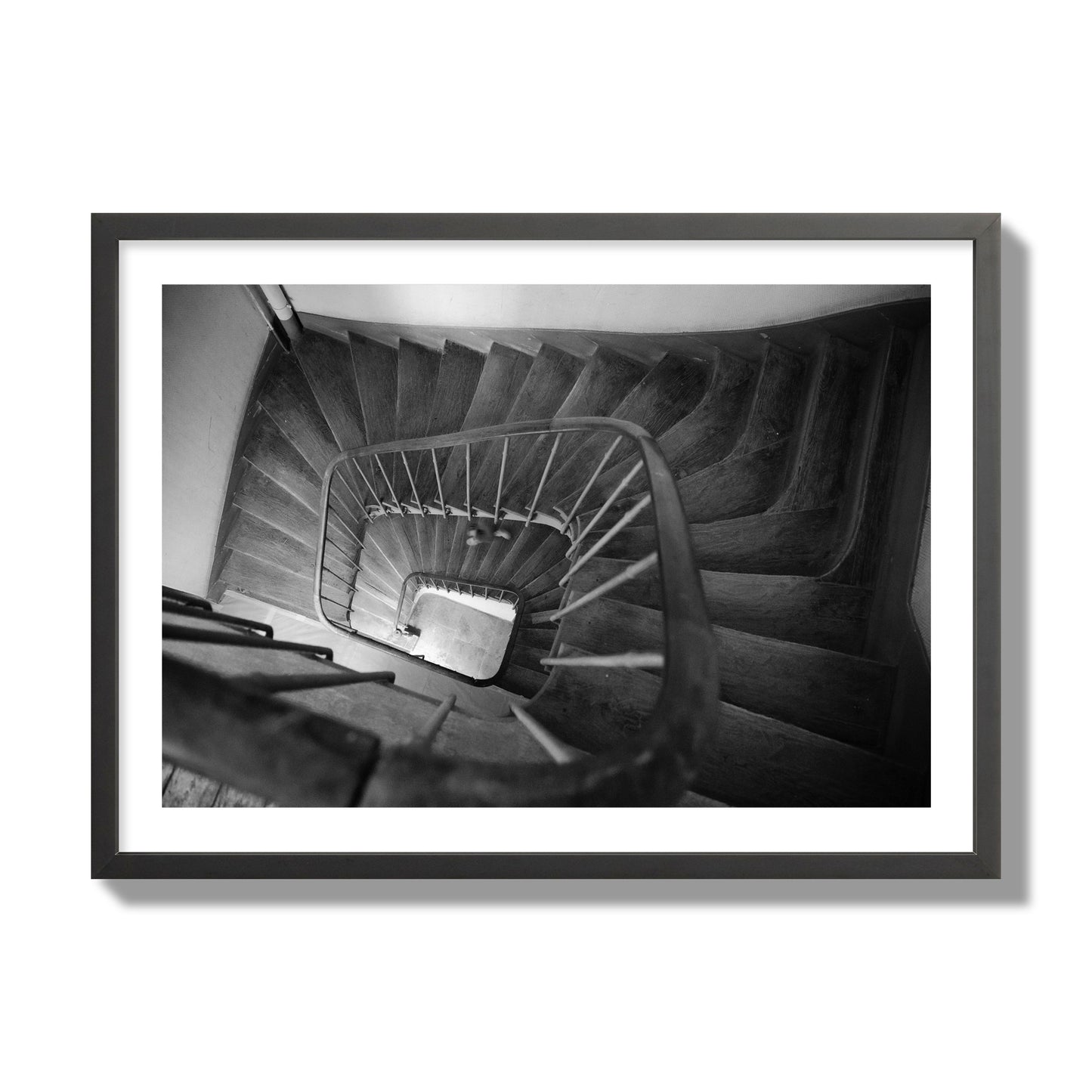 Fine art street photograph of a person walking down a staircase in Paris, France, archival pigment print, giant size, black frame