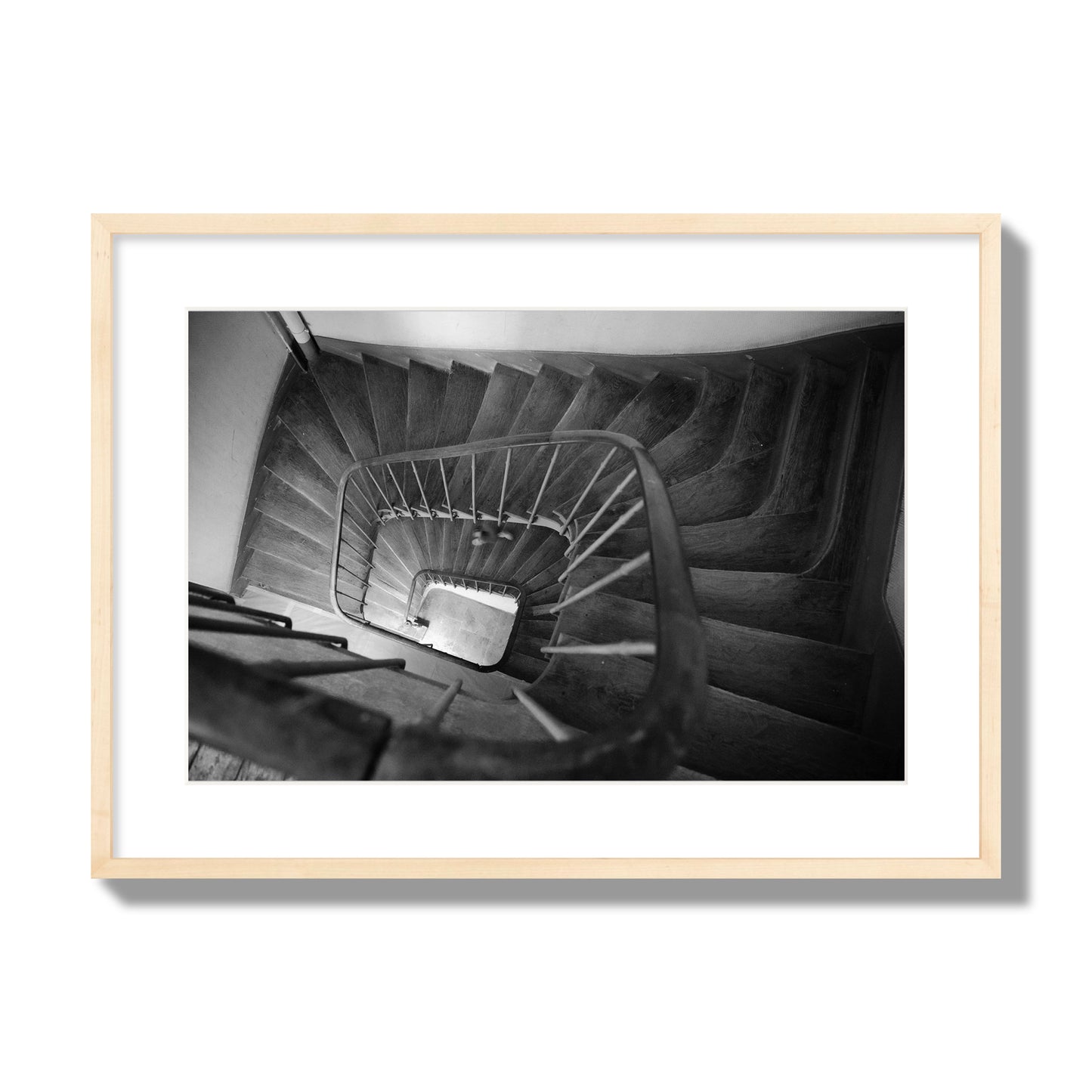 Fine art street photograph of a person walking down a staircase in Paris, France, archival pigment print, large size, natural wood frame