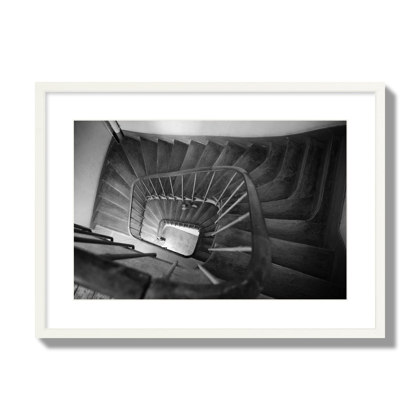 Fine art street photograph of a person walking down a staircase in Paris, France, archival pigment print, large size, white frame