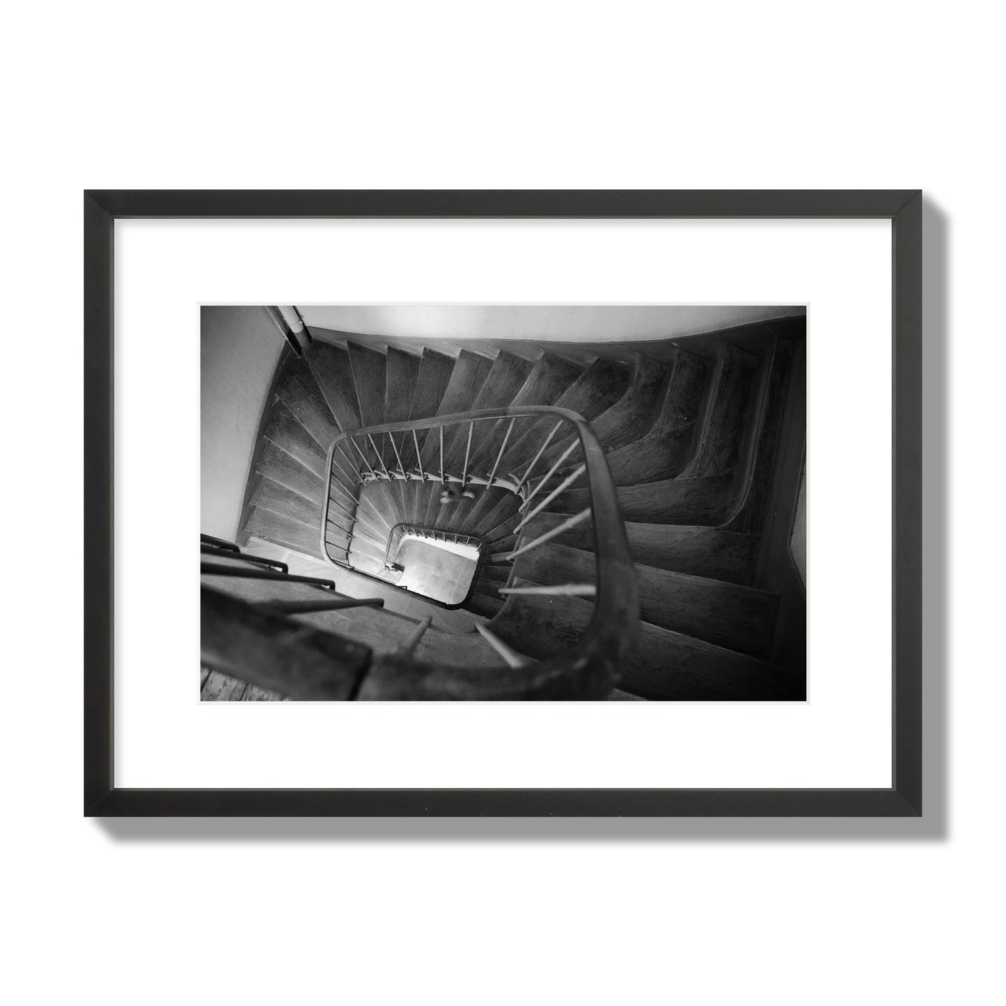 Fine art street photograph of a person walking down a staircase in Paris, France, archival pigment print, medium size, black frame