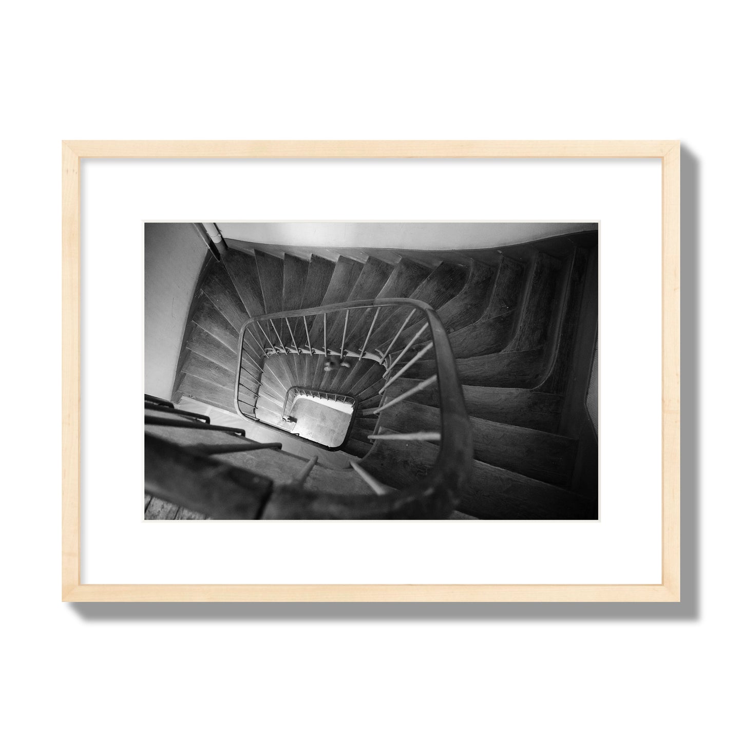 Fine art street photograph of a person walking down a staircase in Paris, France, archival pigment print, medium size, natural wood frame