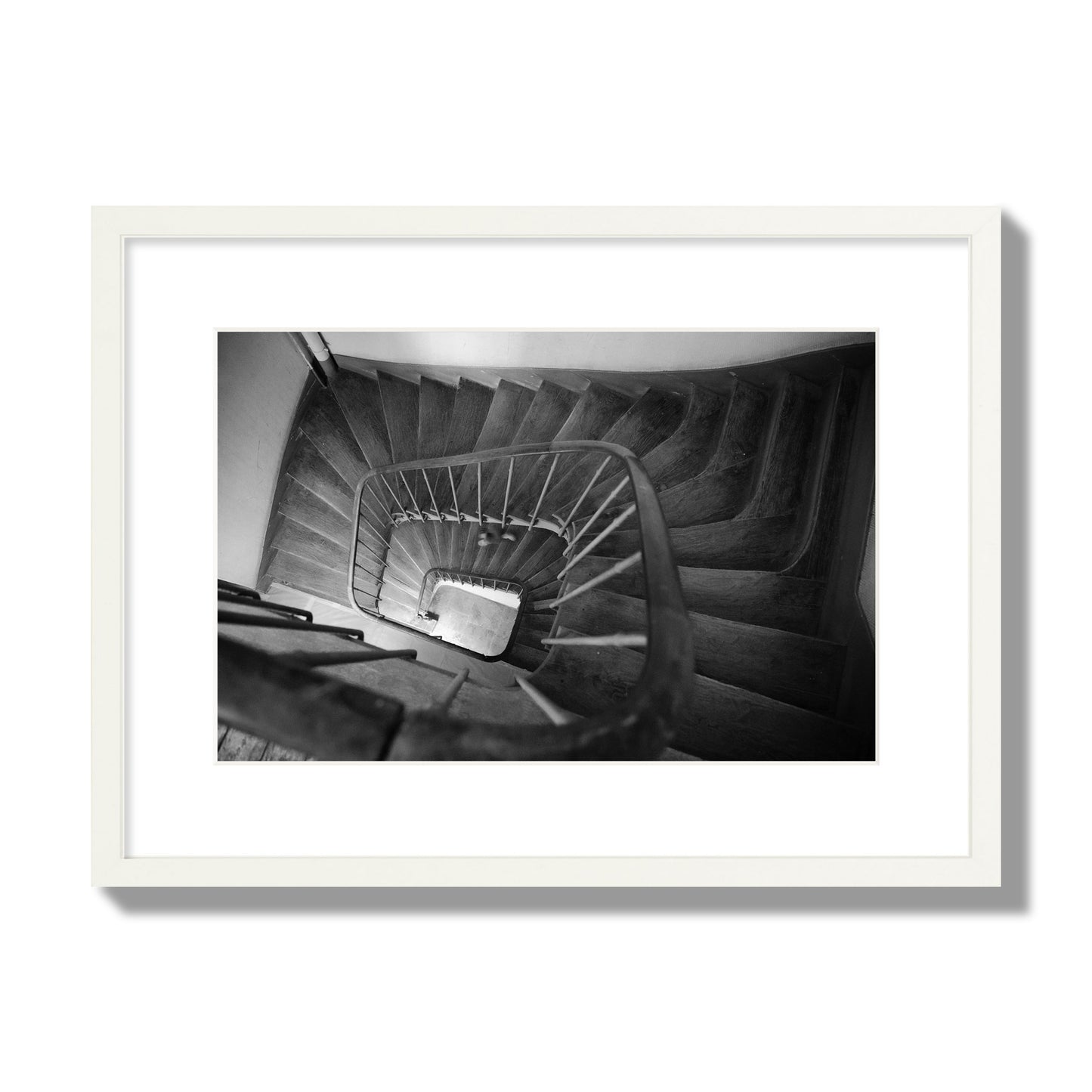 Fine art street photograph of a person walking down a staircase in Paris, France, archival pigment print, medium size, white frame