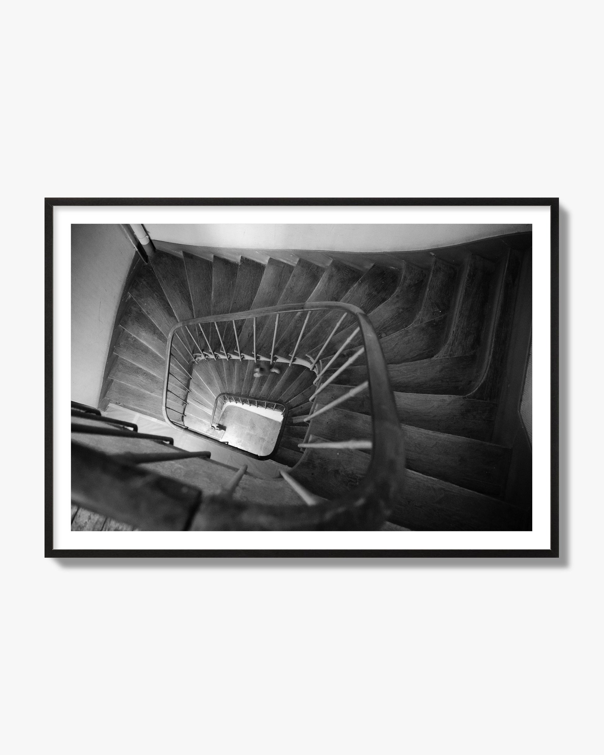 Fine art street photograph of a person walking down a staircase in Paris, France, archival pigment print, black frame