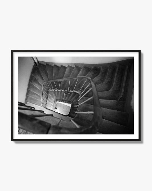 Fine art street photograph of a person walking down a staircase in Paris, France, archival pigment print, black frame