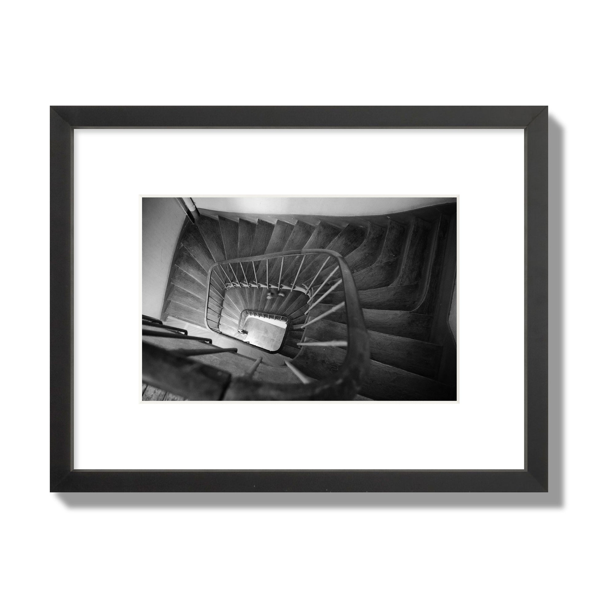 Fine art street photograph of a person walking down a staircase in Paris, France, archival pigment print, small size, black frame