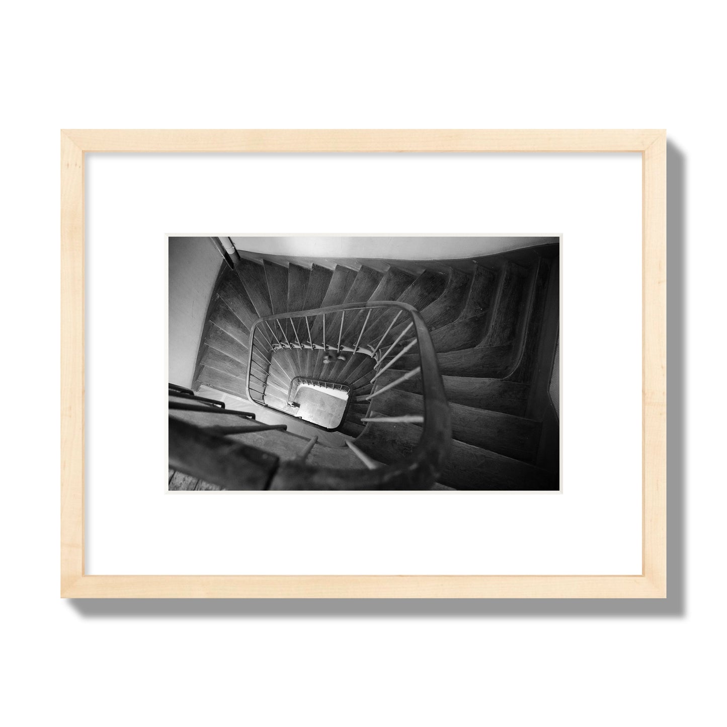 Fine art street photograph of a person walking down a staircase in Paris, France, archival pigment print, small size, natural wood frame