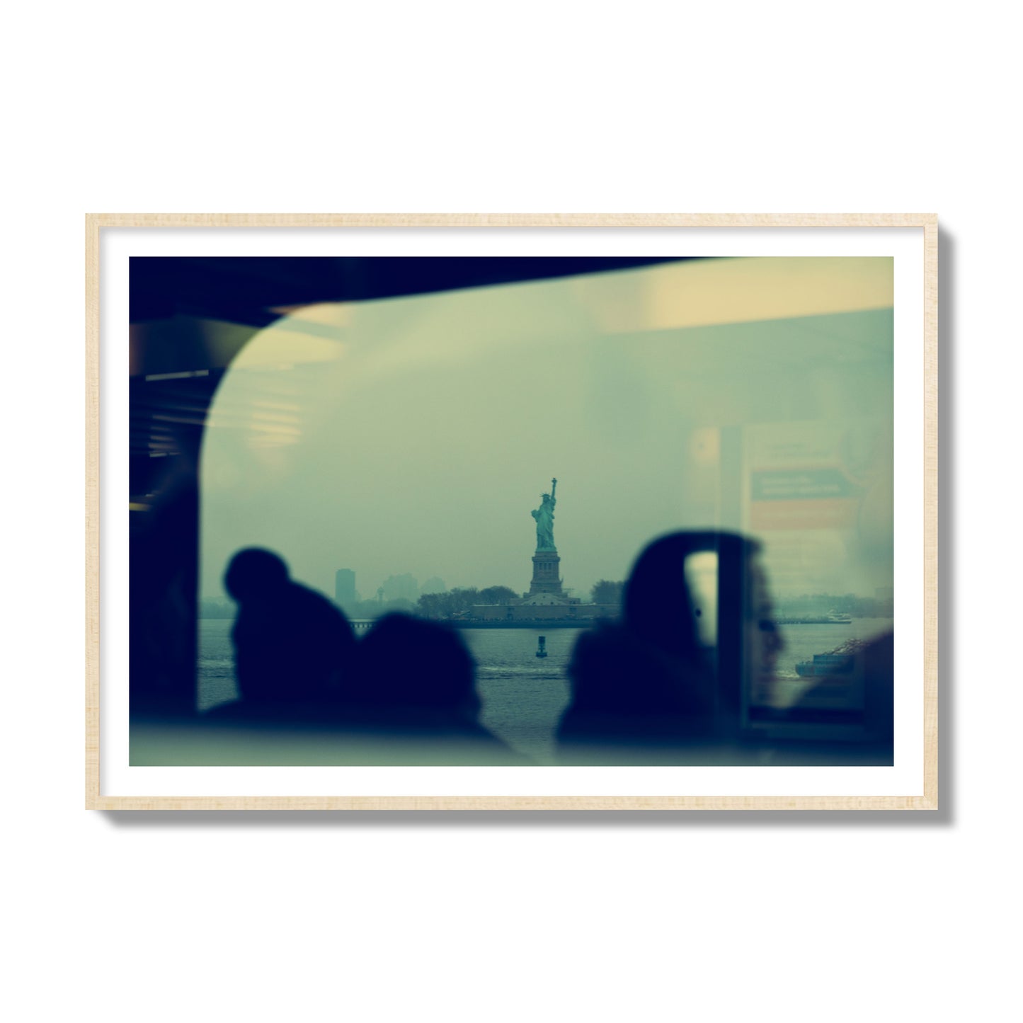 Fine art photograph of passengers silhouetted on a crowded ferry with the Statue of Liberty in the background, archival pigment print, collector size, natural wood frame.