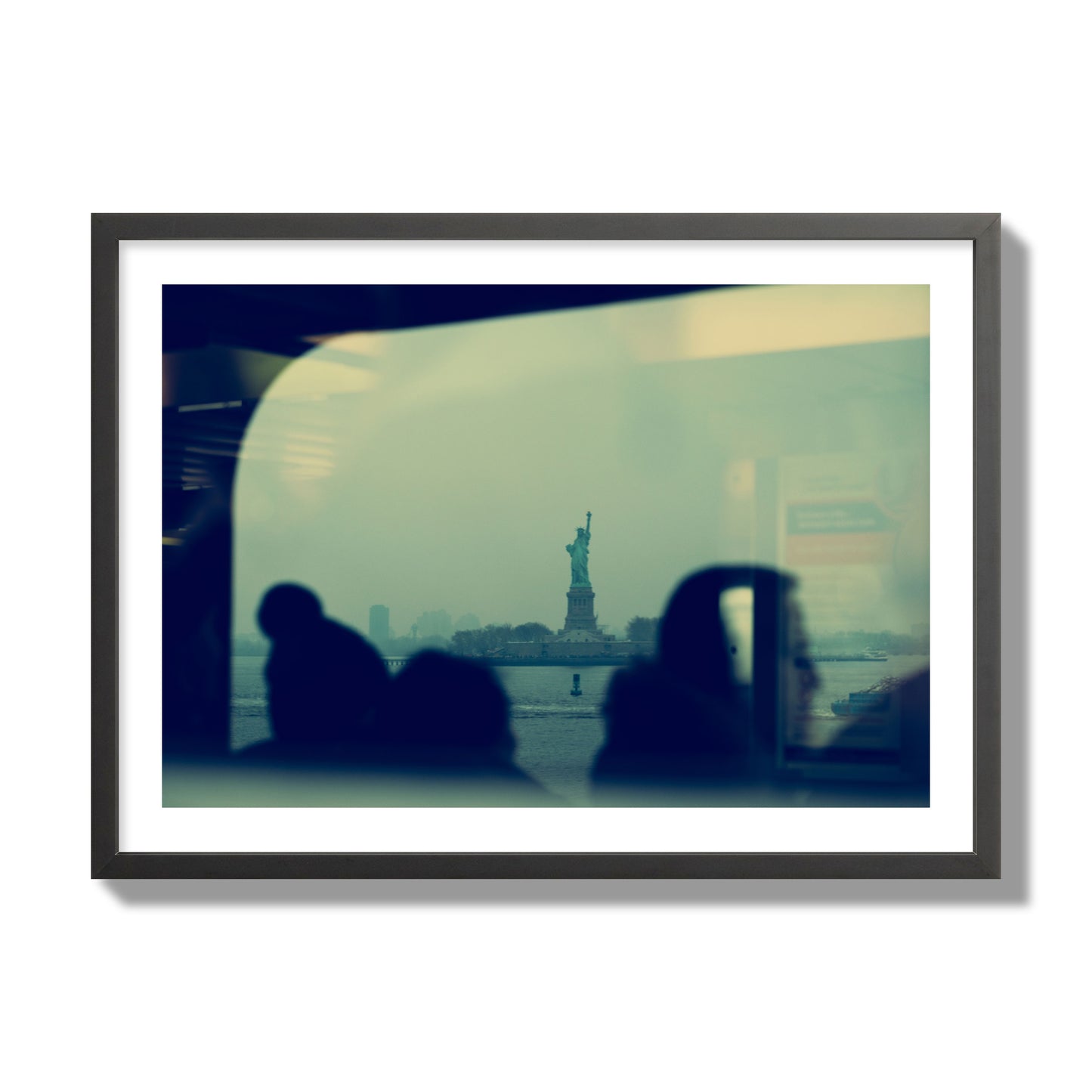 Fine art photograph of passengers silhouetted on a crowded ferry with the Statue of Liberty in the background, archival pigment print, giant size, black frame.