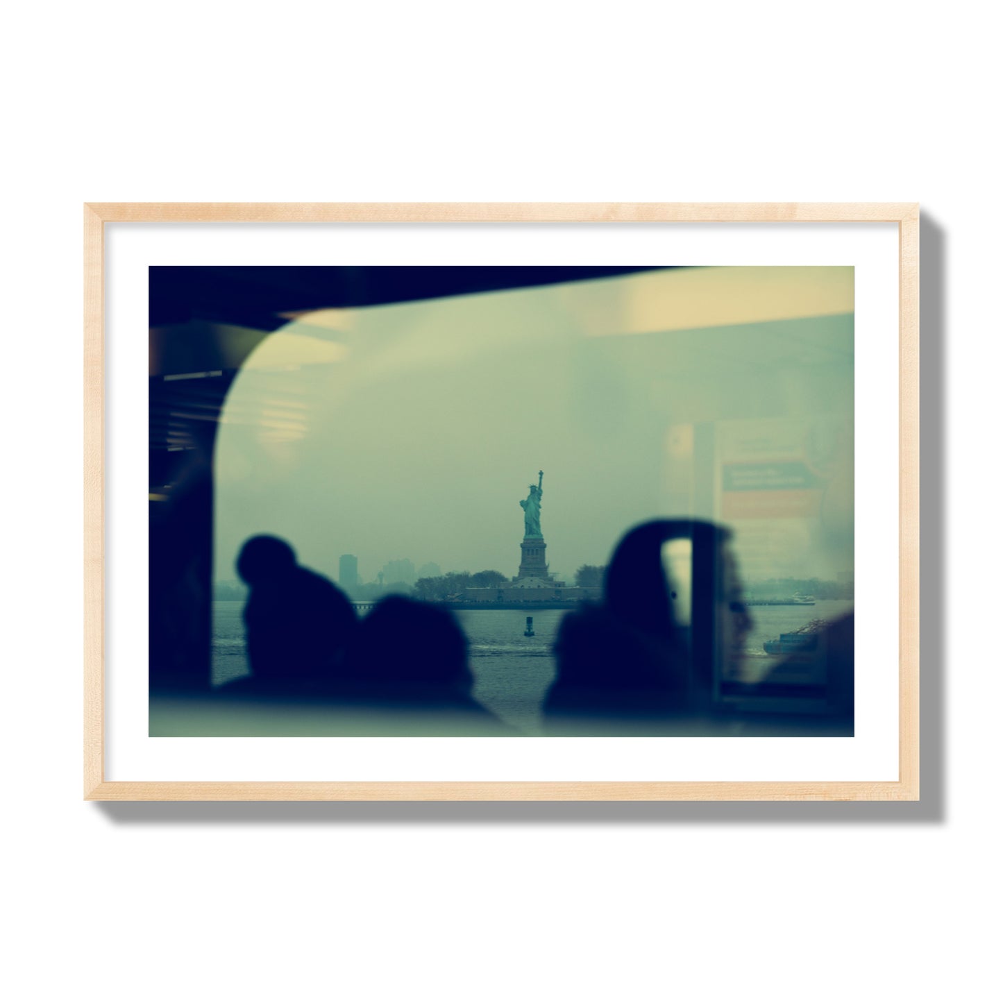 Fine art photograph of passengers silhouetted on a crowded ferry with the Statue of Liberty in the background, archival pigment print, giant size, natural wood frame.