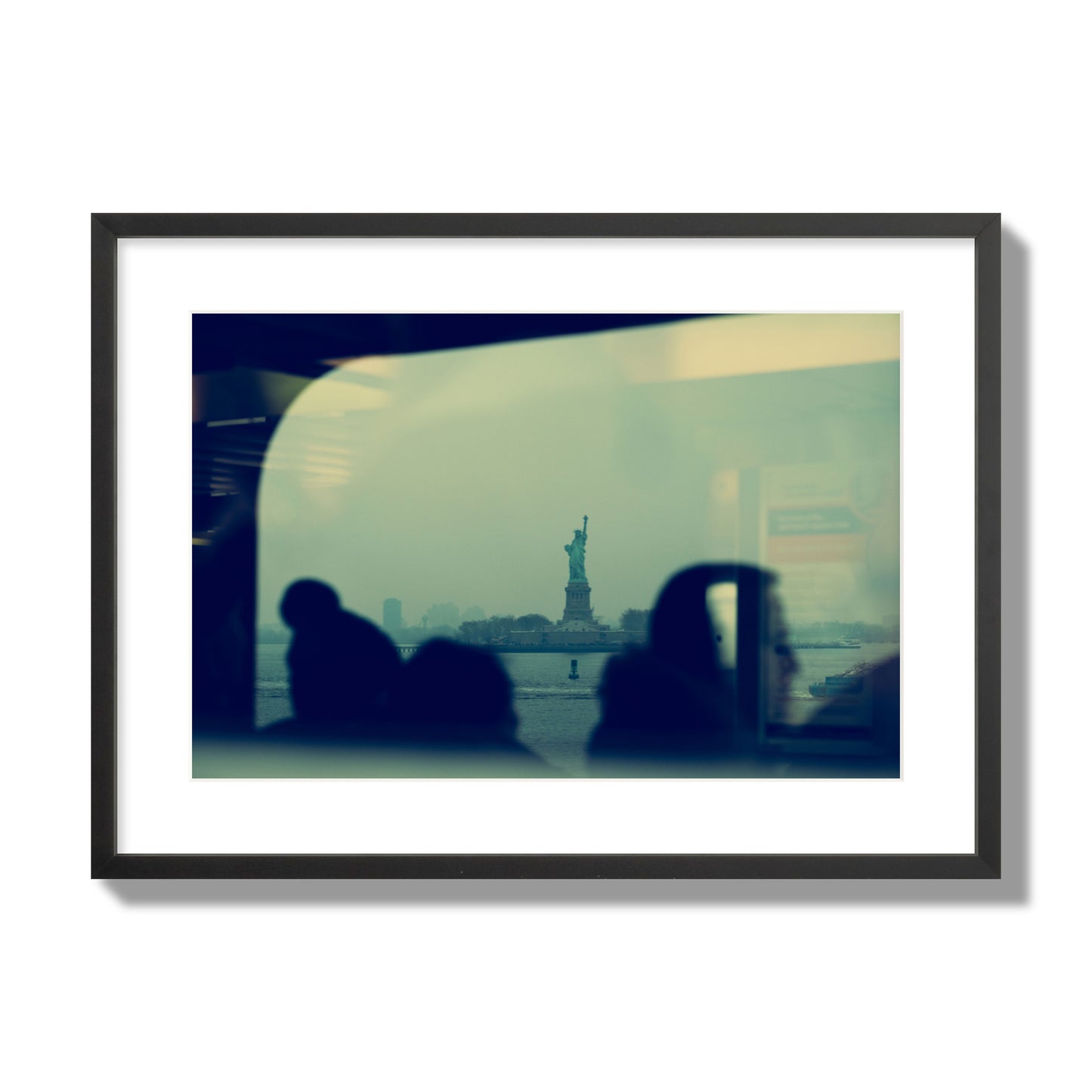 Fine art photograph of passengers silhouetted on a crowded ferry with the Statue of Liberty in the background, archival pigment print, large size, black frame.
