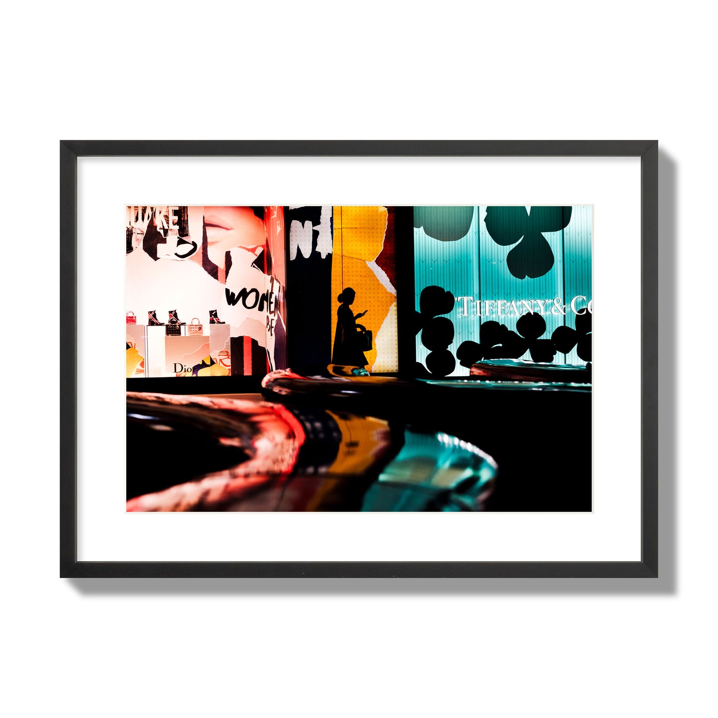 Fine art photograph of a woman’s silhouette walking past vibrant neon store signs, archival pigment print, large size, black frame.