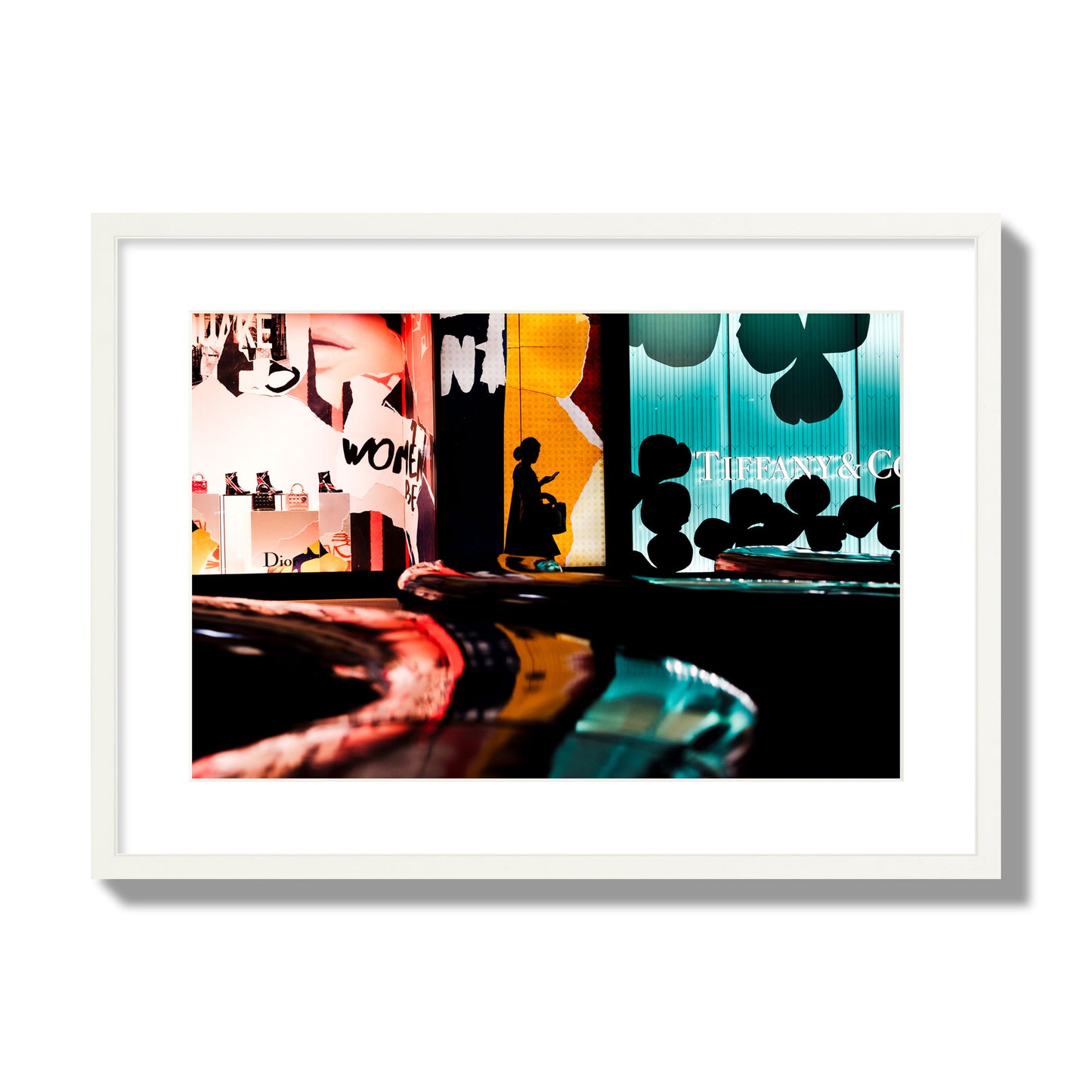 Fine art photograph of a woman’s silhouette walking past vibrant neon store signs, archival pigment print, large size, white frame.