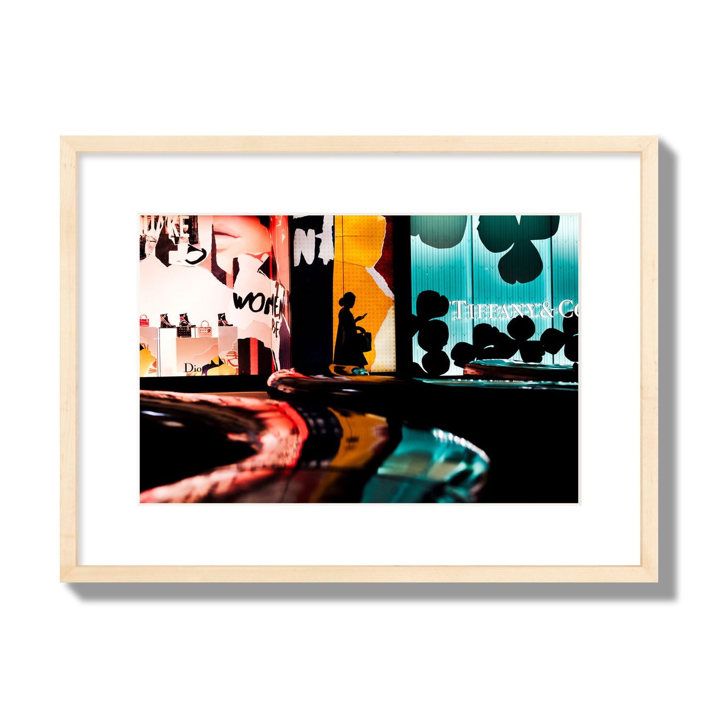 Fine art photograph of a woman’s silhouette walking past vibrant neon store signs, archival pigment print, medium size, natural wood frame.