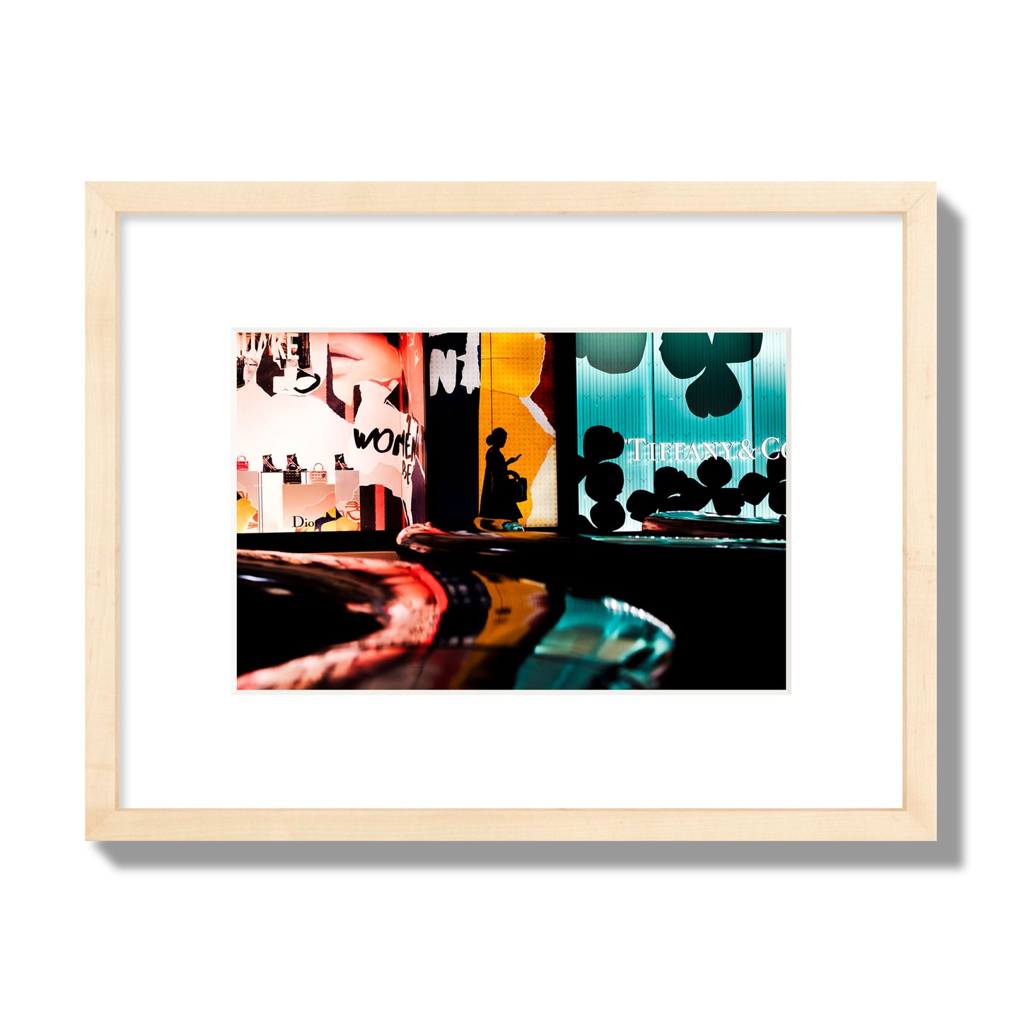 Fine art photograph of a woman’s silhouette walking past vibrant neon store signs, archival pigment print, small size, natural wood frame.