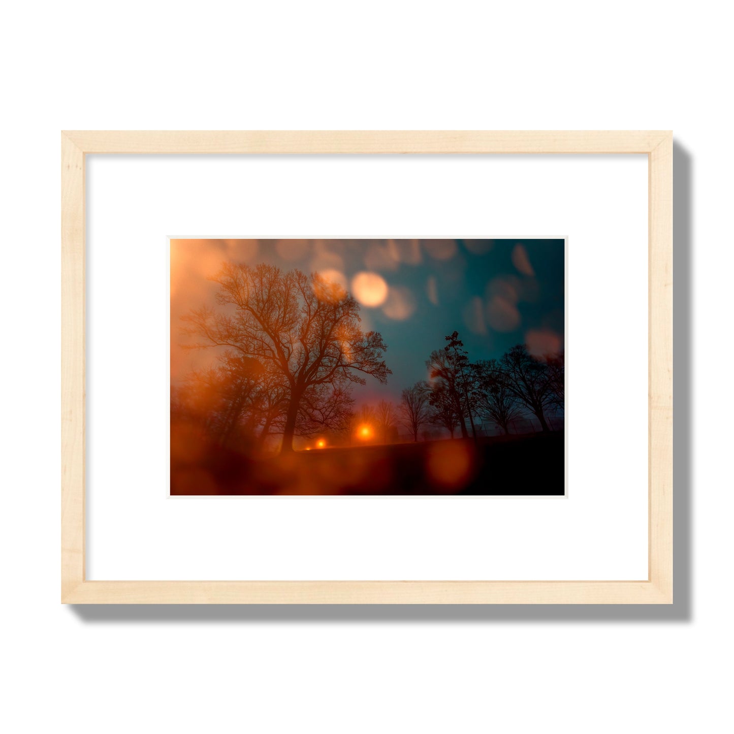 Fine art landscape photograph of a tranquil forest illuminated by orange-red streetlights. Archival pigment print, small size, natural wood frame.