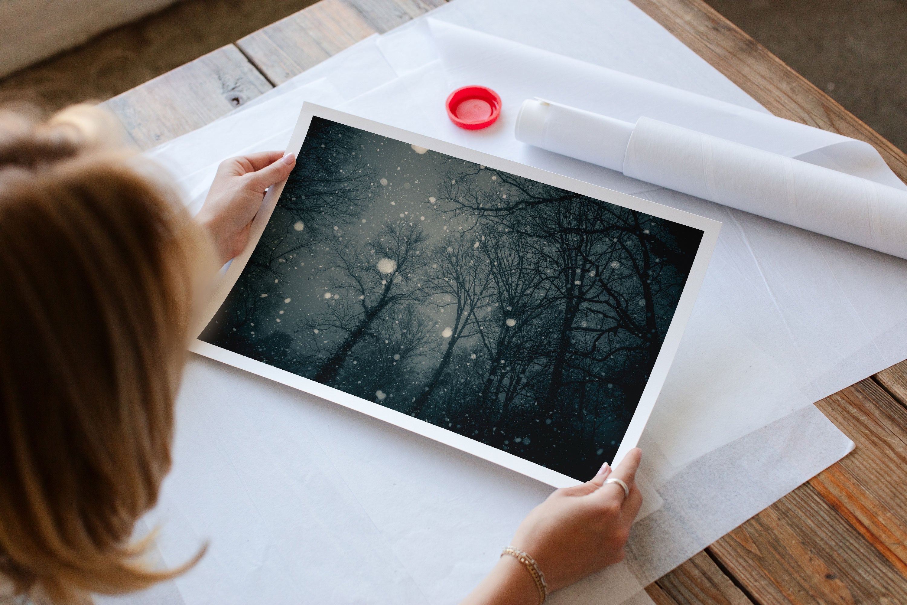 An artist studio with a printed fine art landscape photograph featuring snowfall in a forest.
